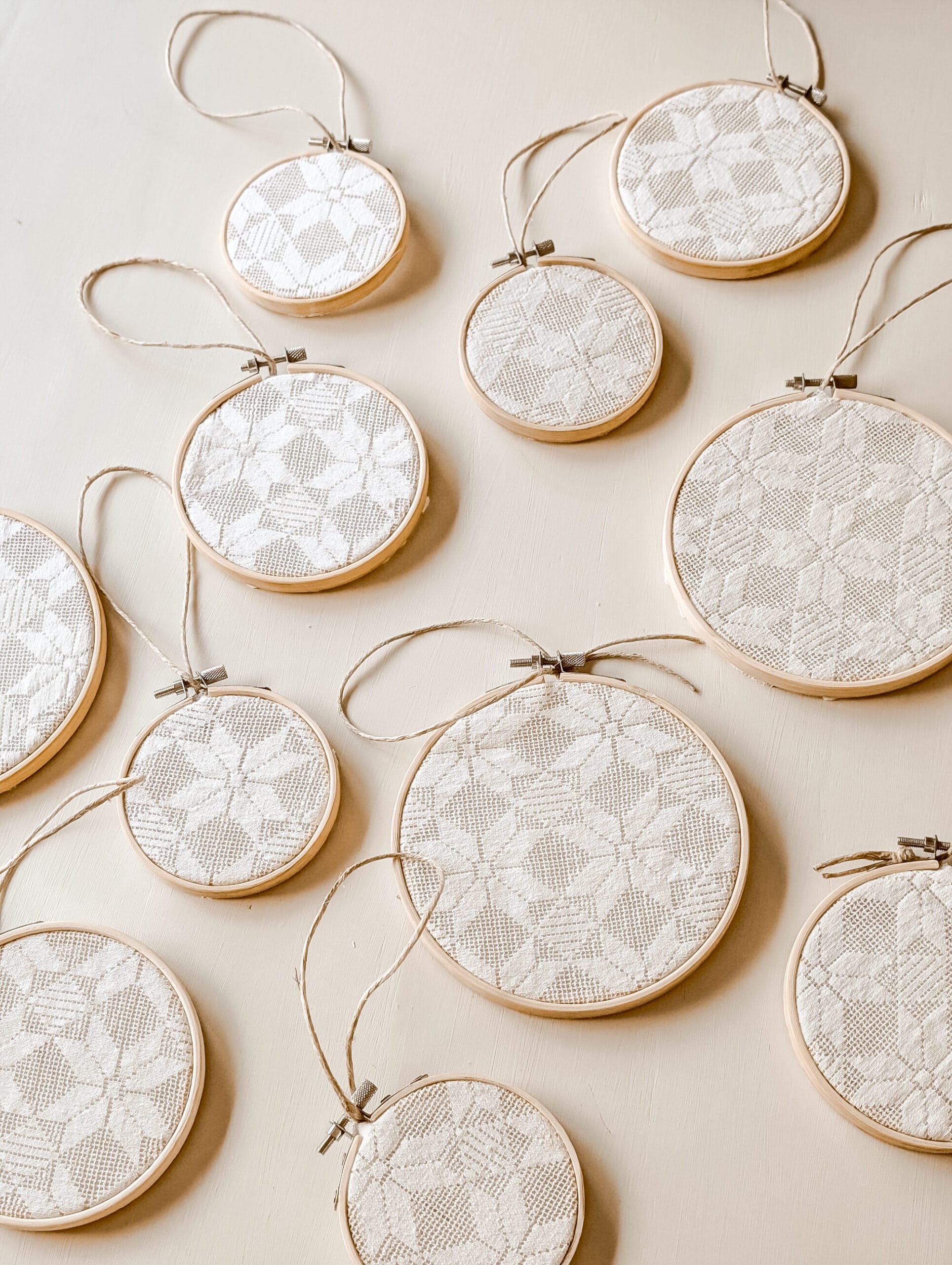 DIY embroidery hoop Christmas ornaments made with a lace doily fabric and twine ornament hanger