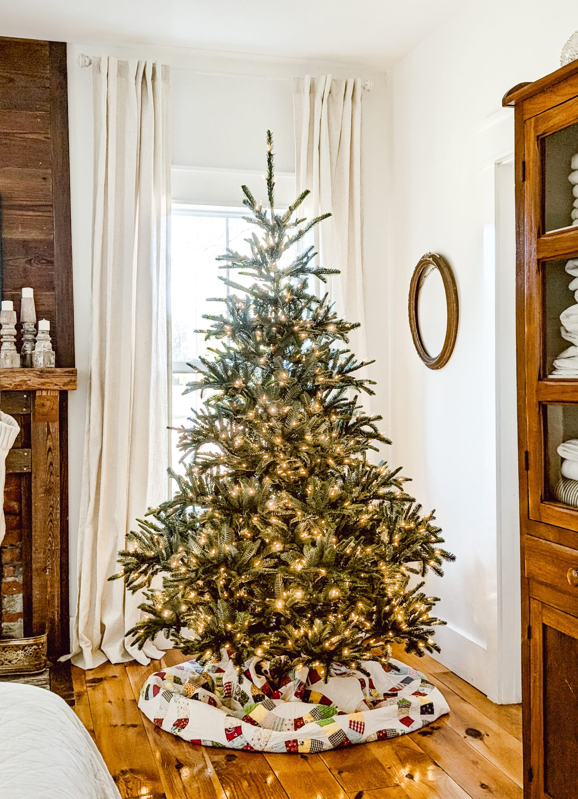 real life look at Balsam Hill's Nordmann Fir fluffed but not yet decorated, and with an antique quilt as a tree skirt and white lights