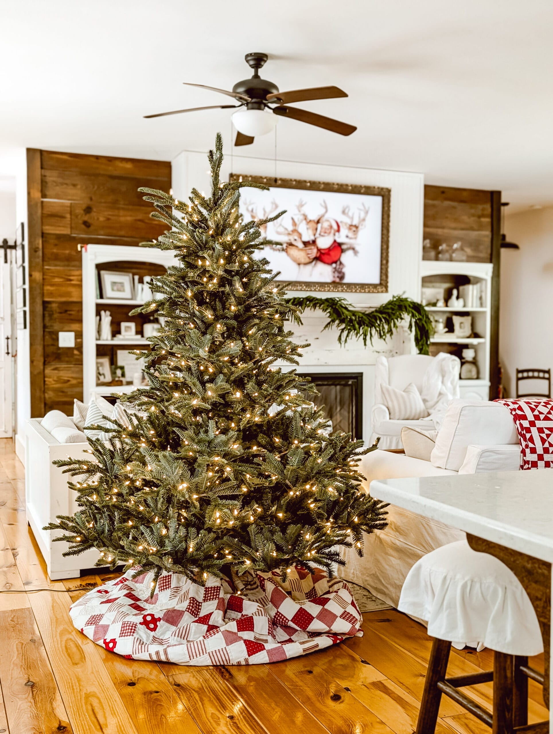 Balsam Hill's European Fir Christmas tree all fluffed in our farmhouse living room with a red and white quilt as a makeshift tree skirt