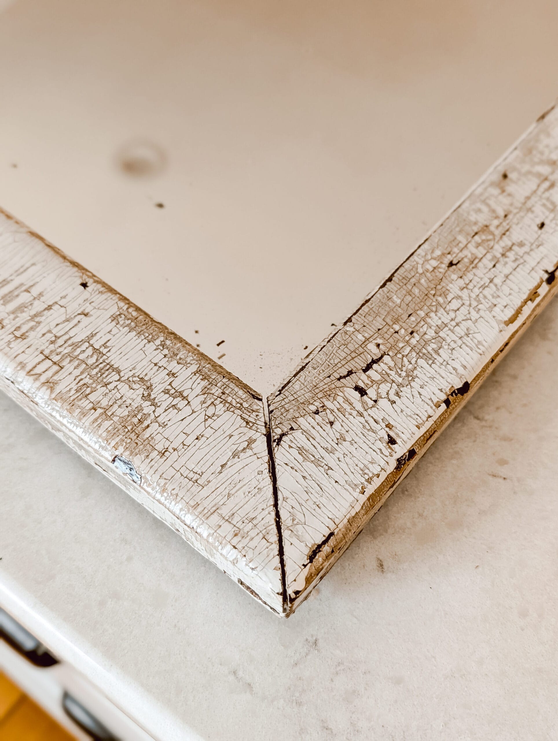 chippy paint texture on the wood frame of a vintage mirror