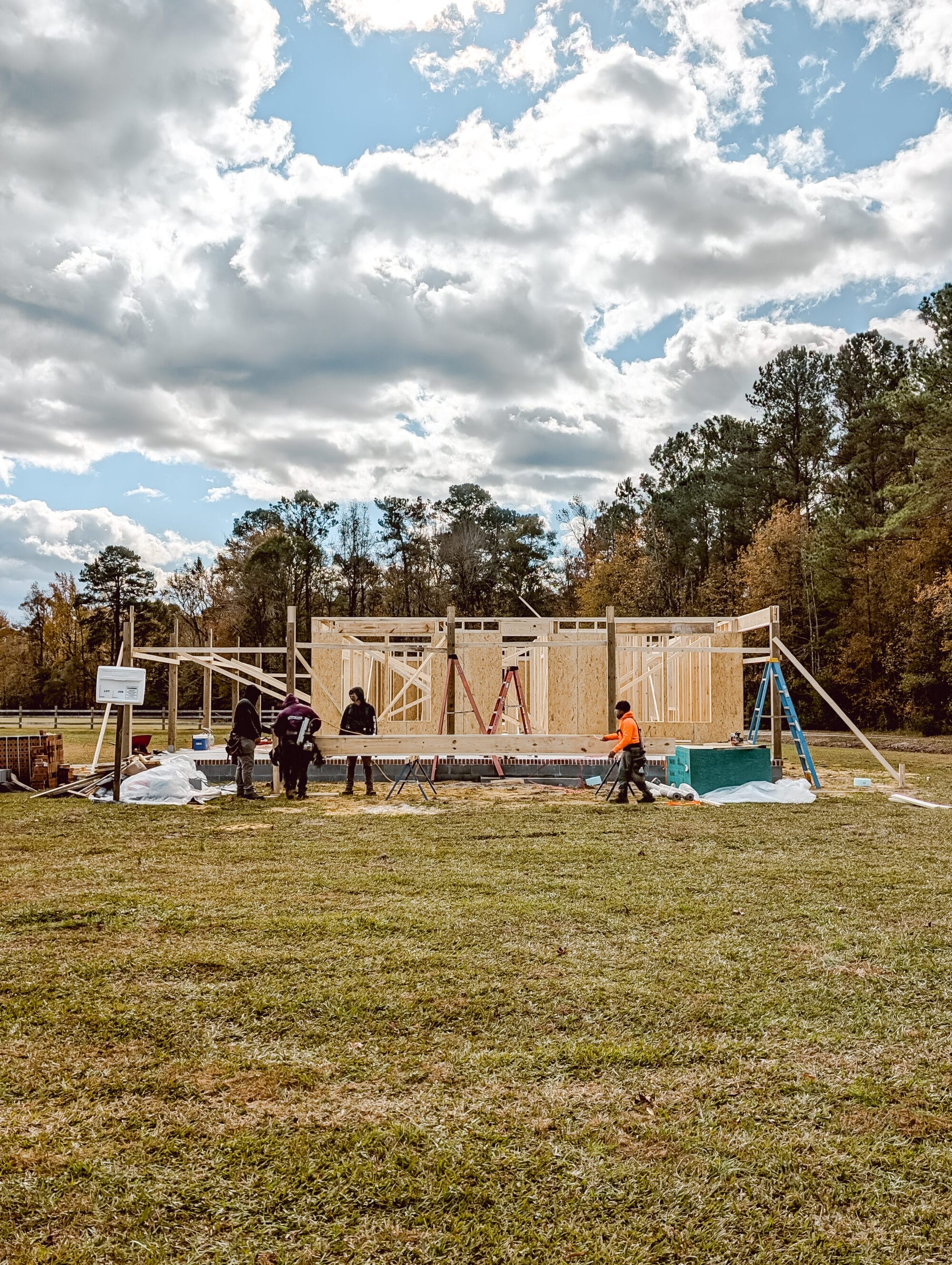 construction workers carrying wood and framing a small 2 bedroom cottage