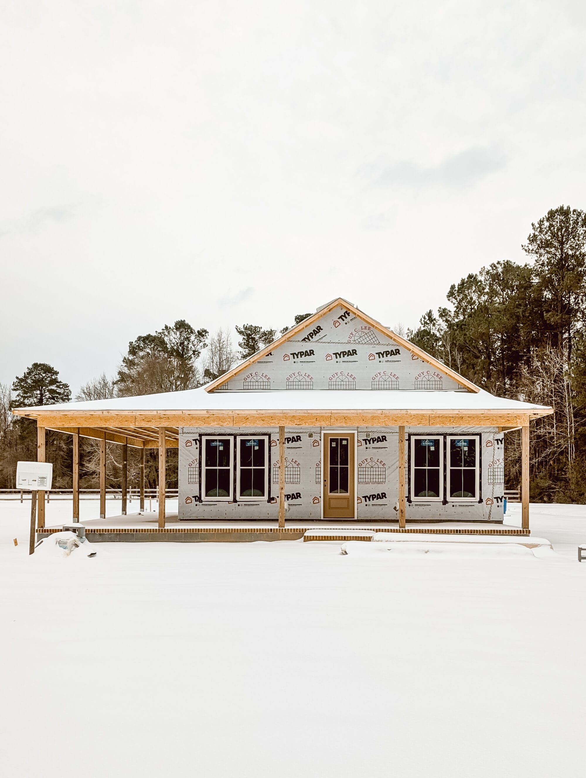 a new old cottage under construction after a fresh snow has fallen on it