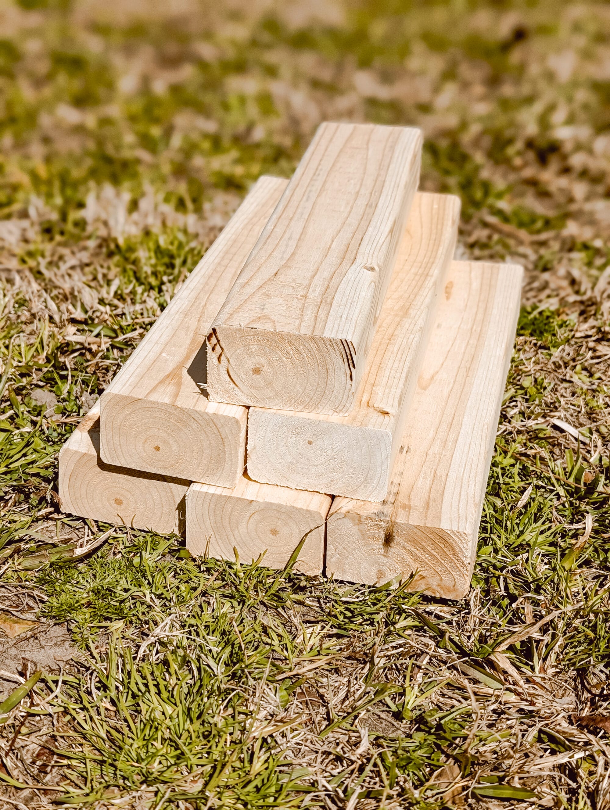 stack of 2 x 4 lumber cut into 11 inch long sections to make a raised garden bed