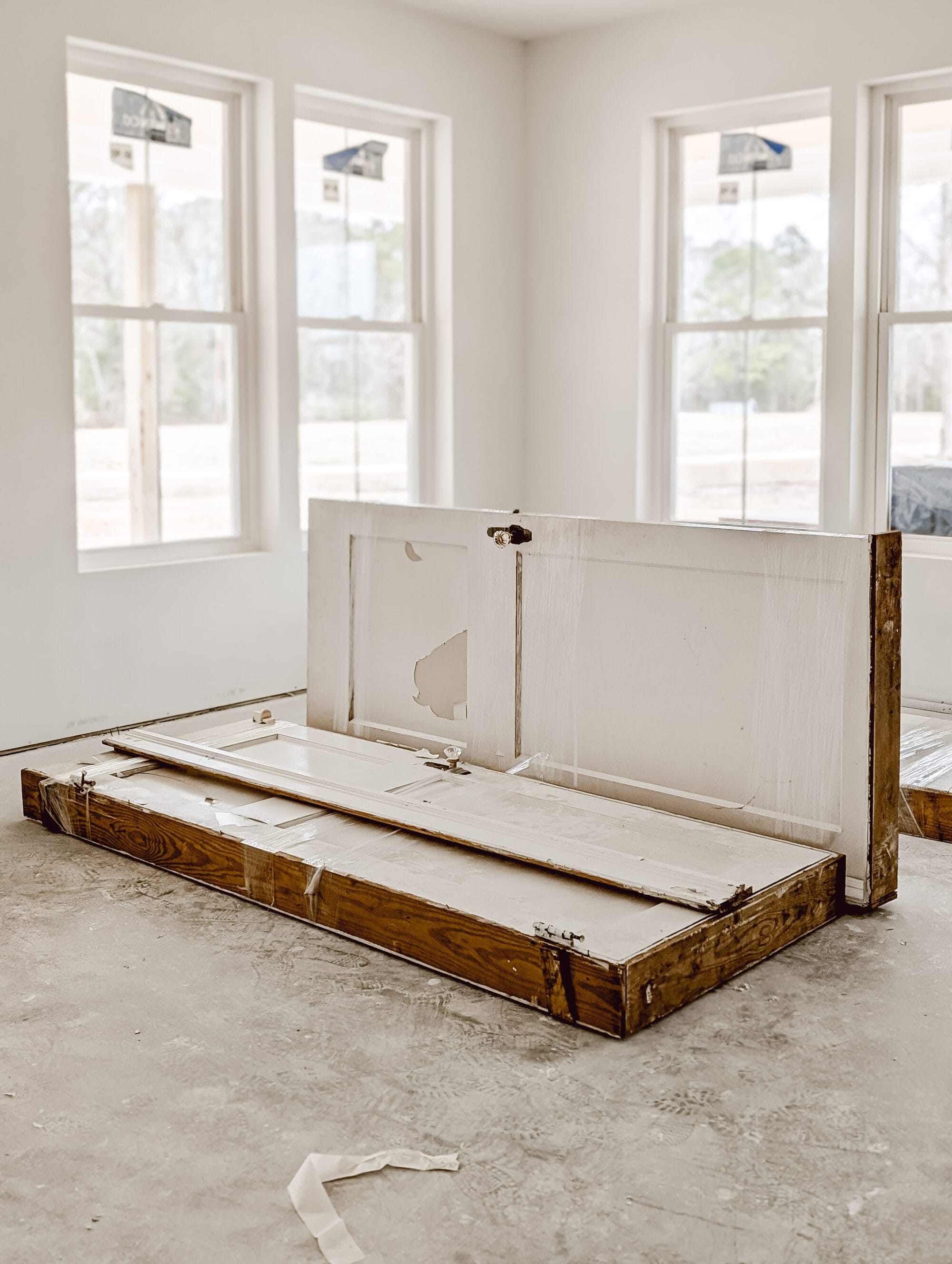 salvaged antique doors with white chippy paint and the original brass and crystal door knobs