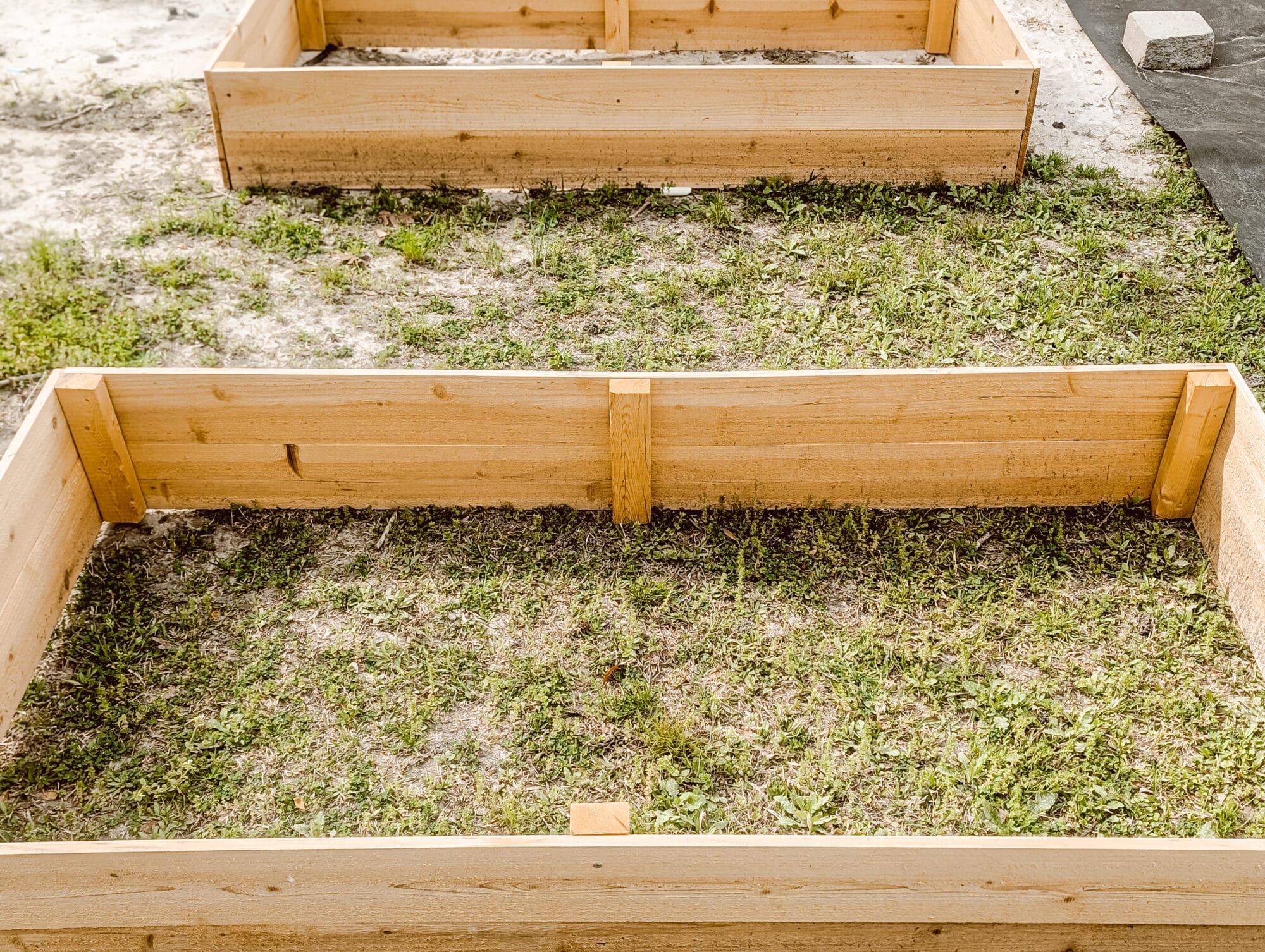 2 x 4 support boards inside a wood raised garden bed