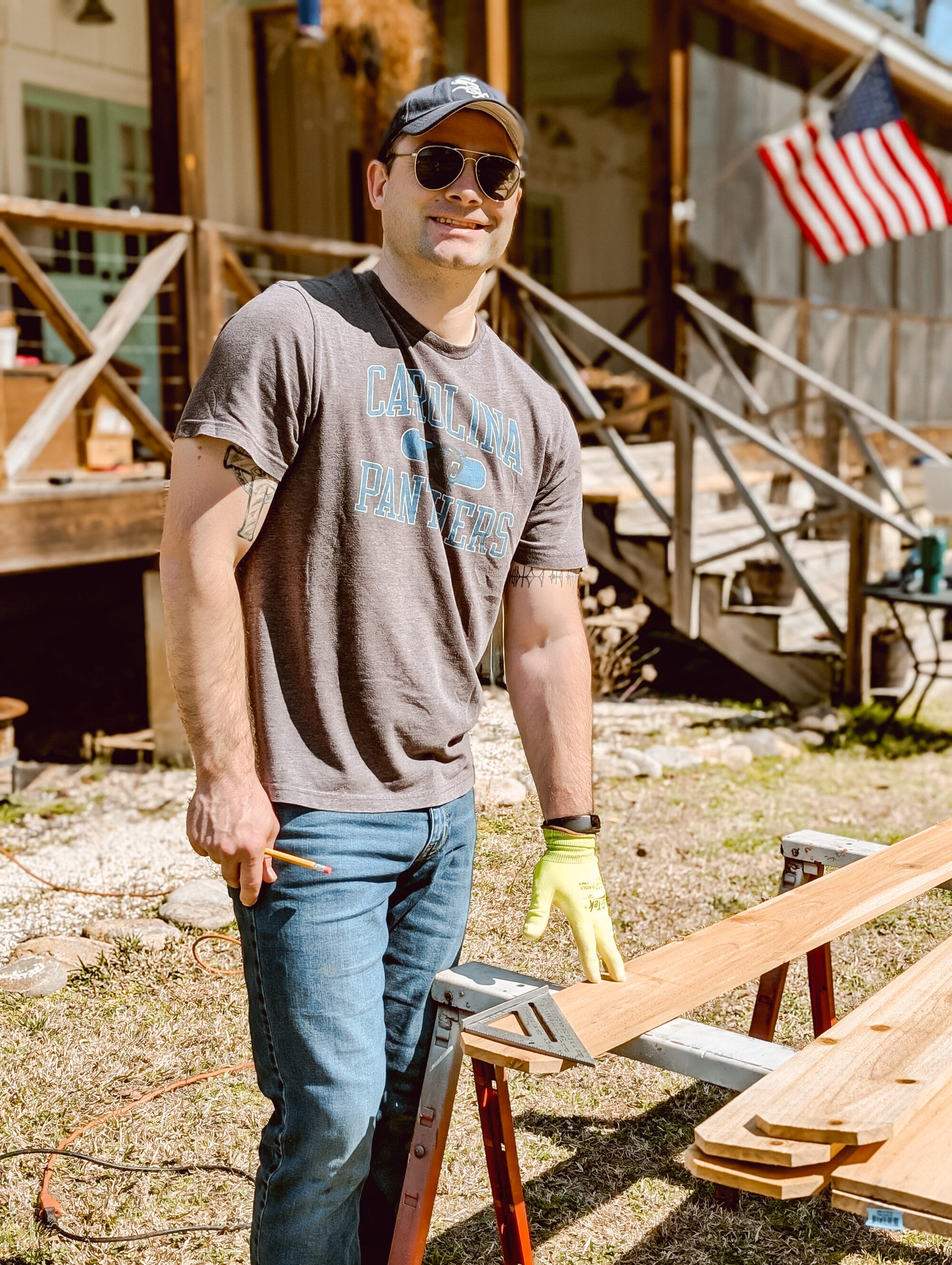 husband working on DIY cedar raised garden beds and cutting the dog-eared part of the cedar fence picket off