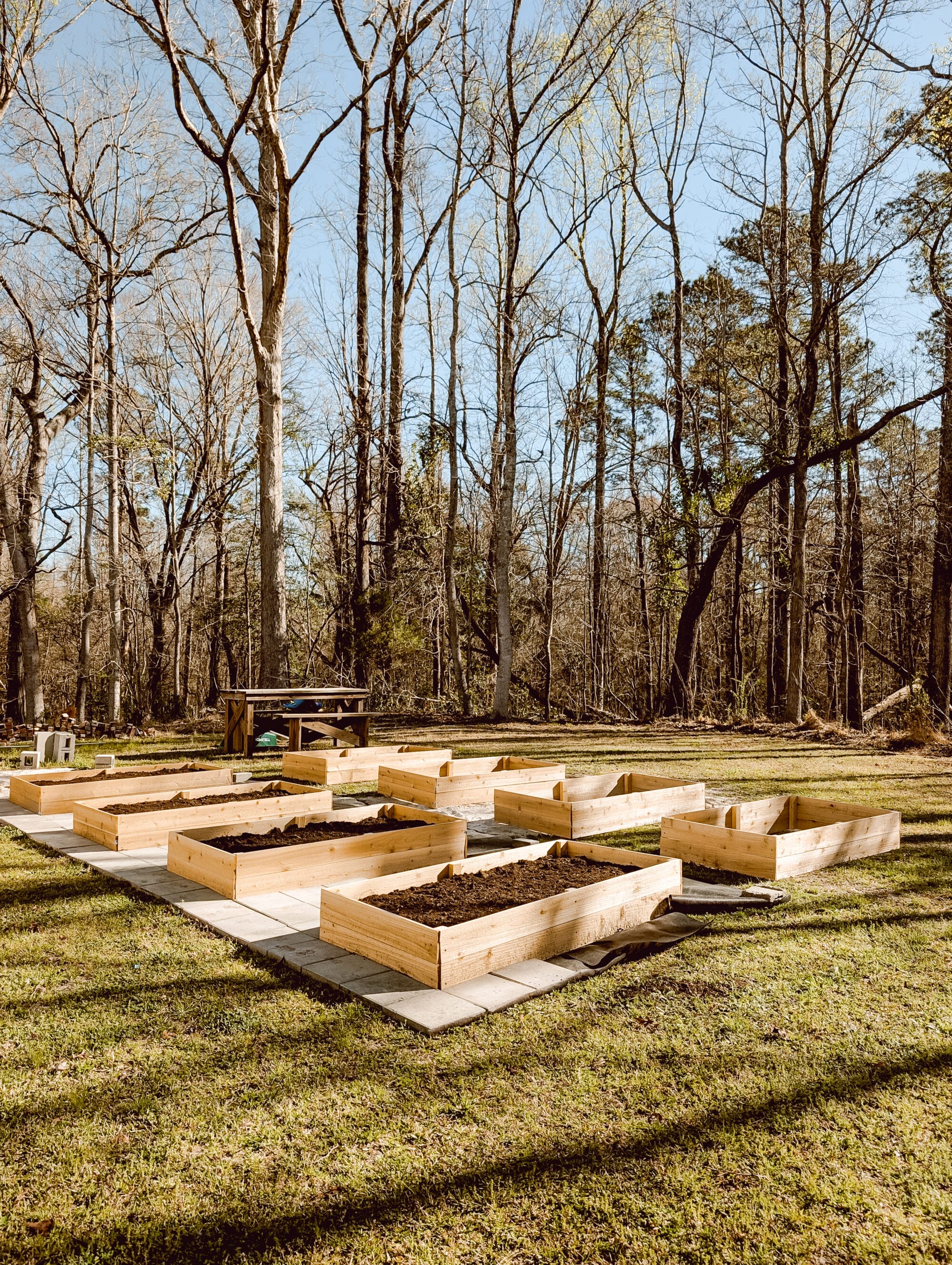 8 raised garden beds with concrete paver walkways in between the beds