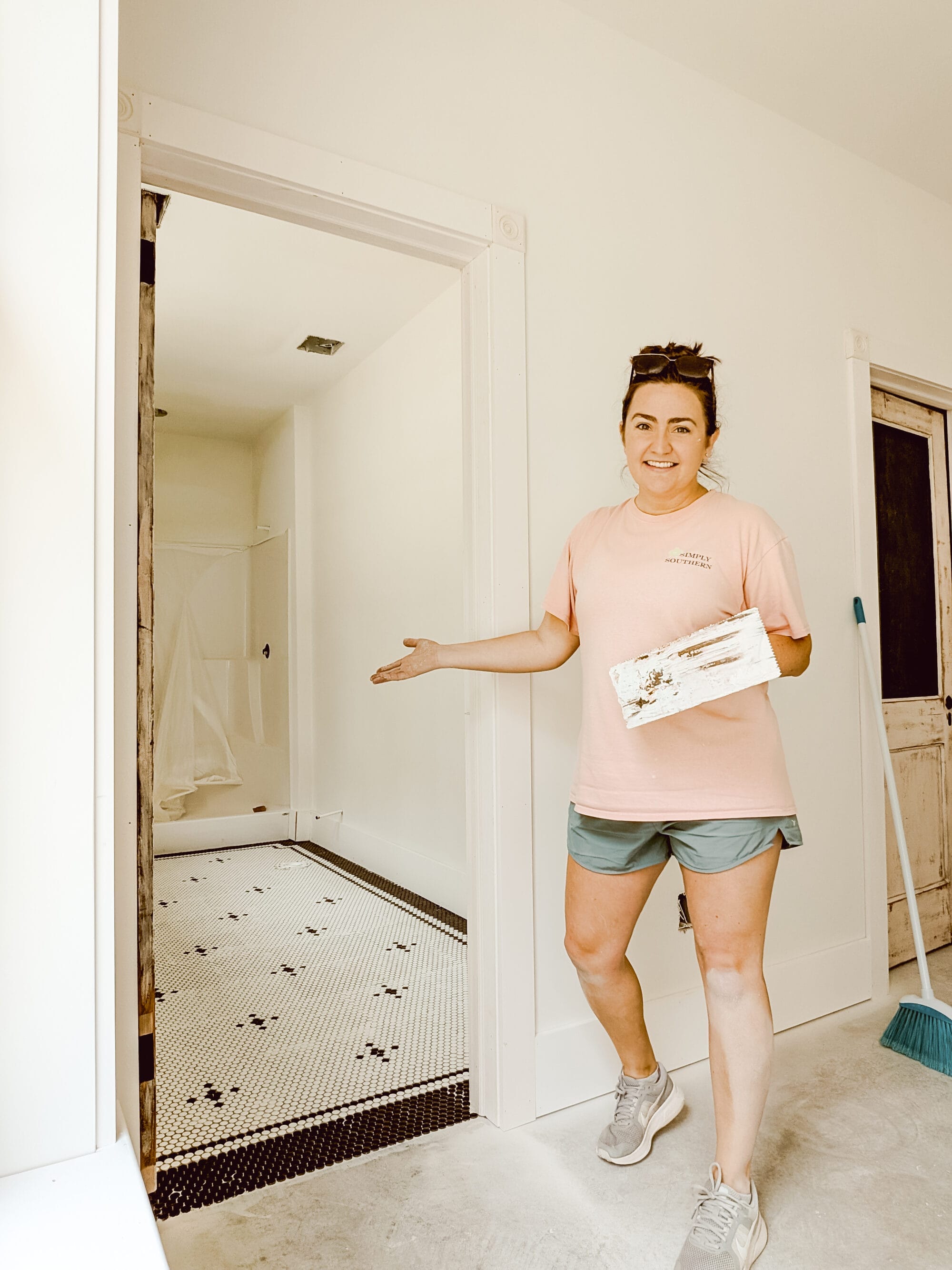 admiring my hard work laying penny tile on the floors of our new old cottage bathroom