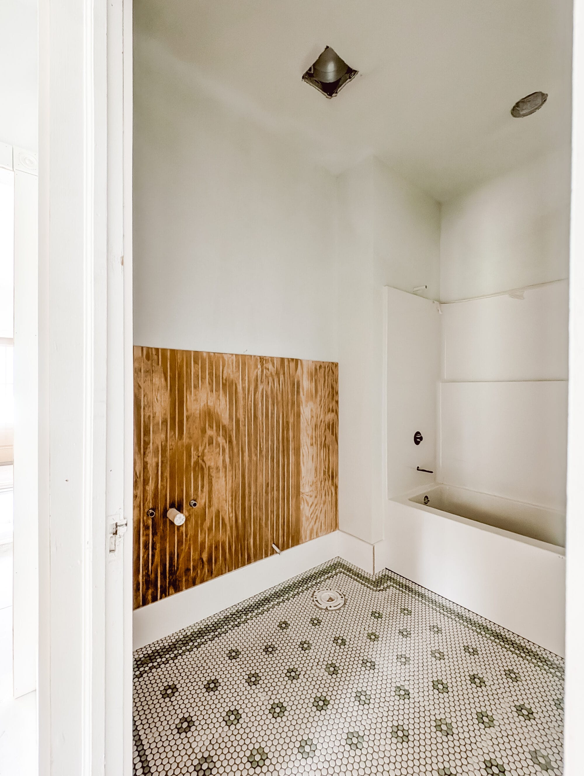 cottage guest bathroom with penny tile floors under construction