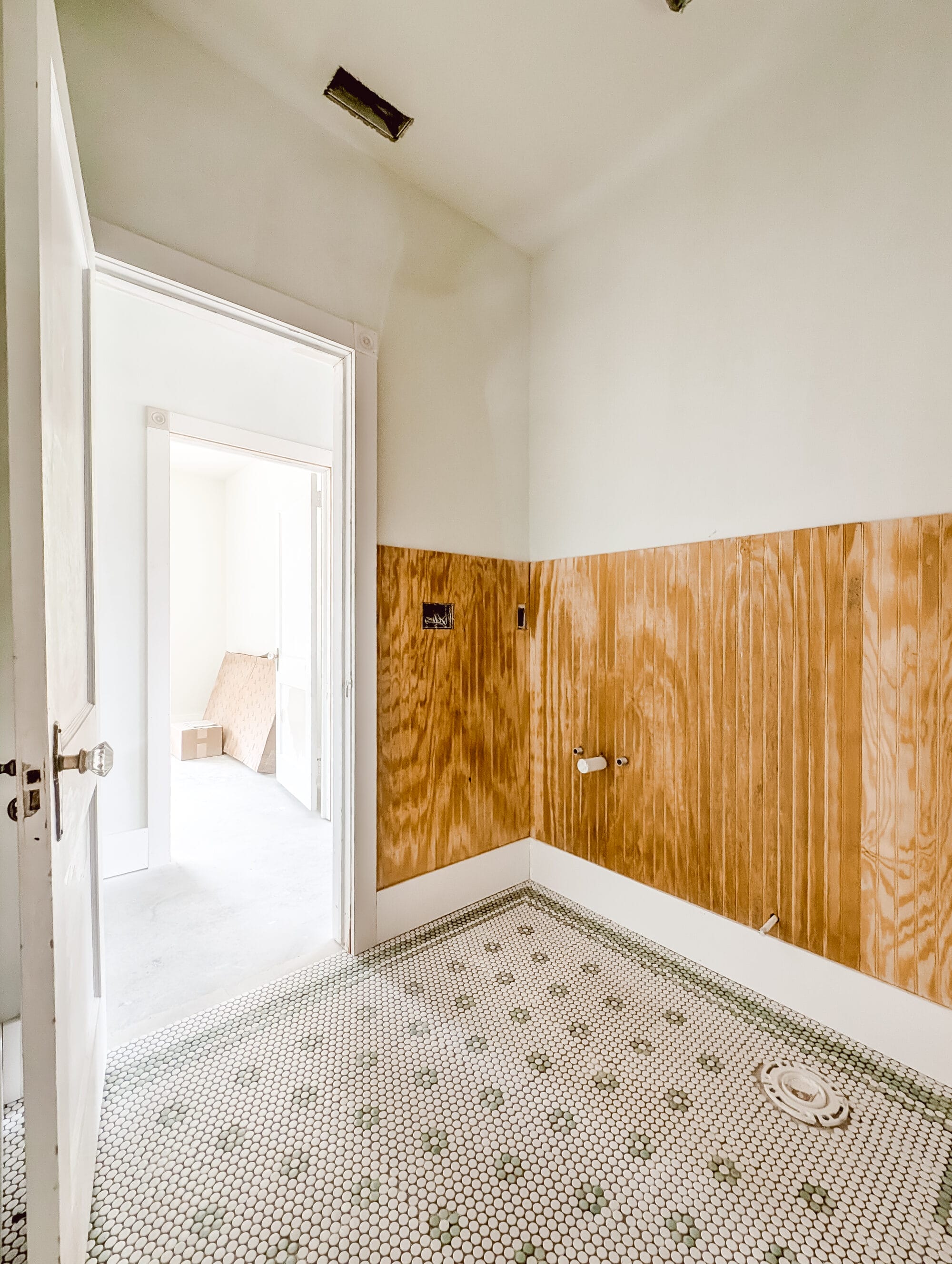 vintage cottage guest bathroom progress with mint green and white penny tile in a daisy pattern and beadboard paneling on the walls