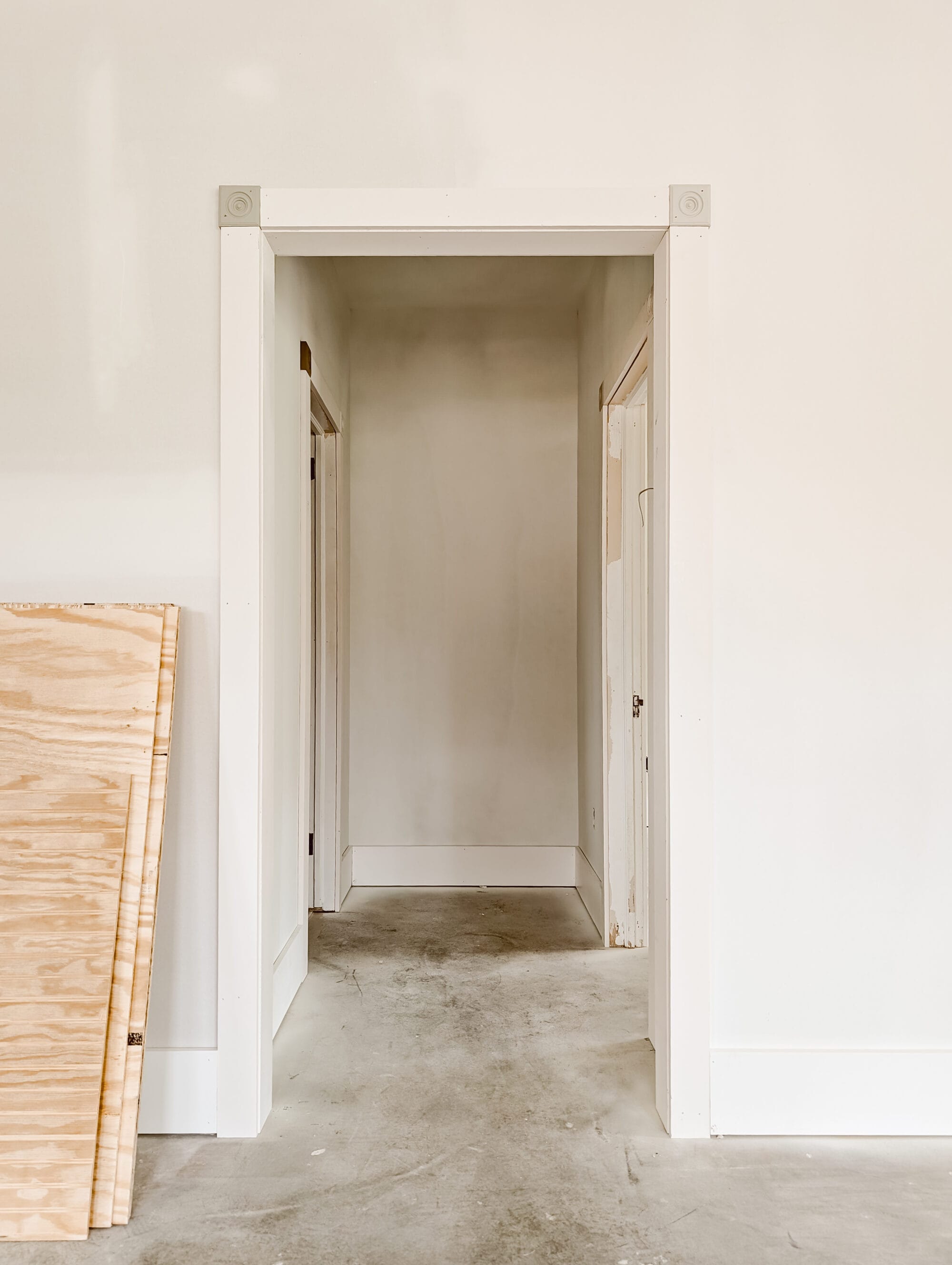 small unfinished hallway with a cased opening leading to the guest bedroom and guest bath