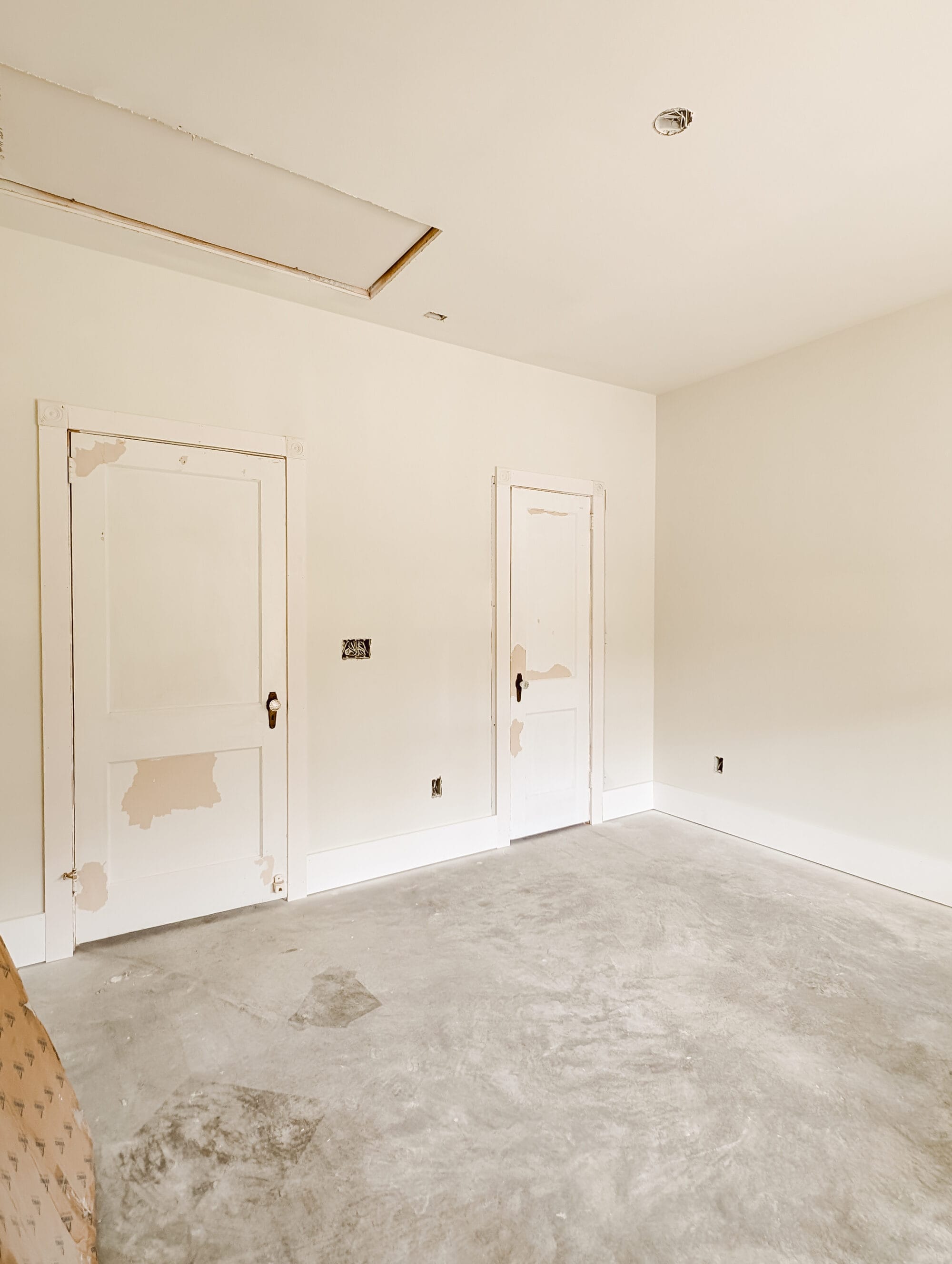 two salvaged antique doors with brass and crystal knobs hung up in the guest bedroom