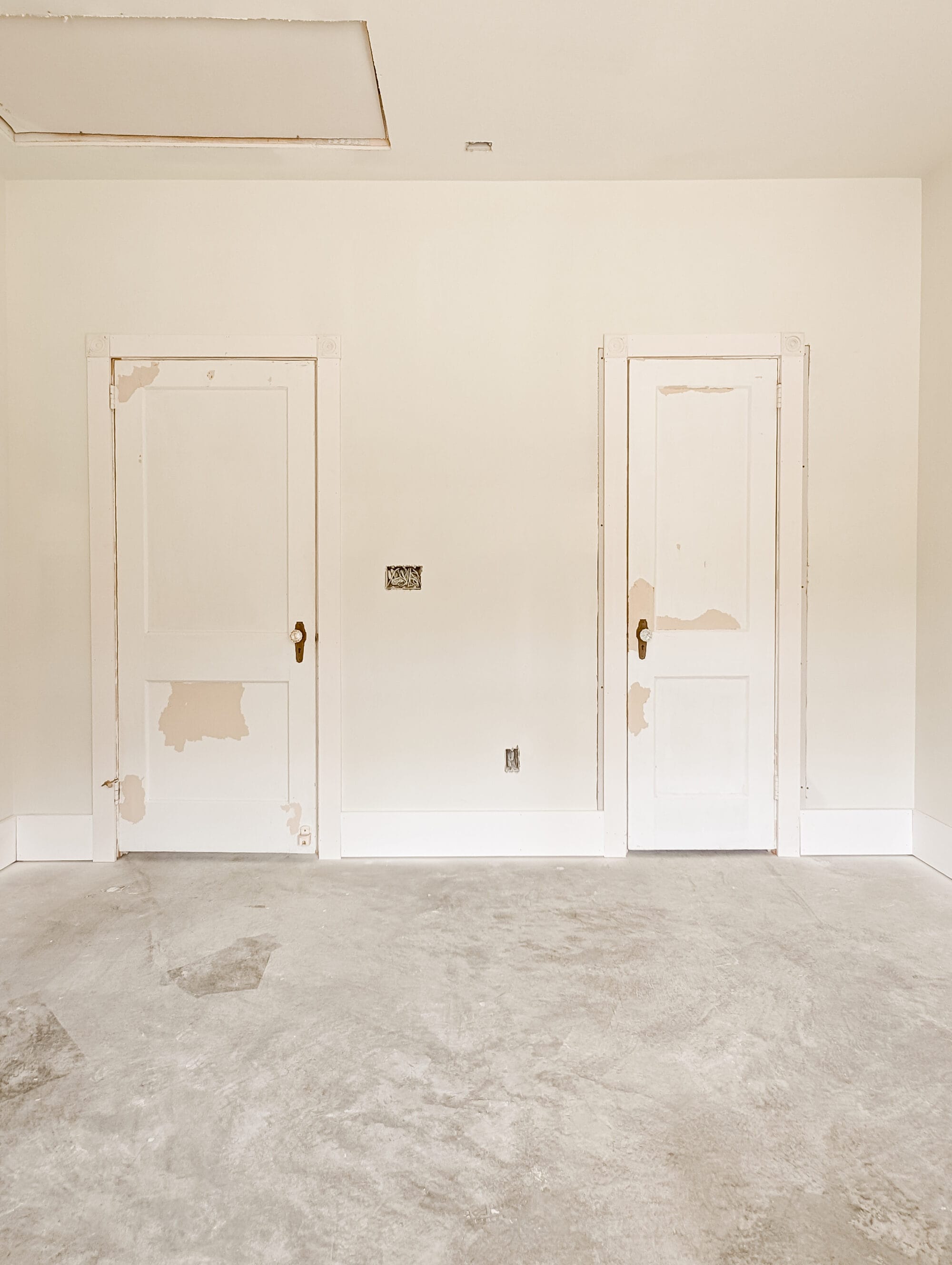 two salvaged antique doors with brass and crystal knobs hung up in the guest bedroom