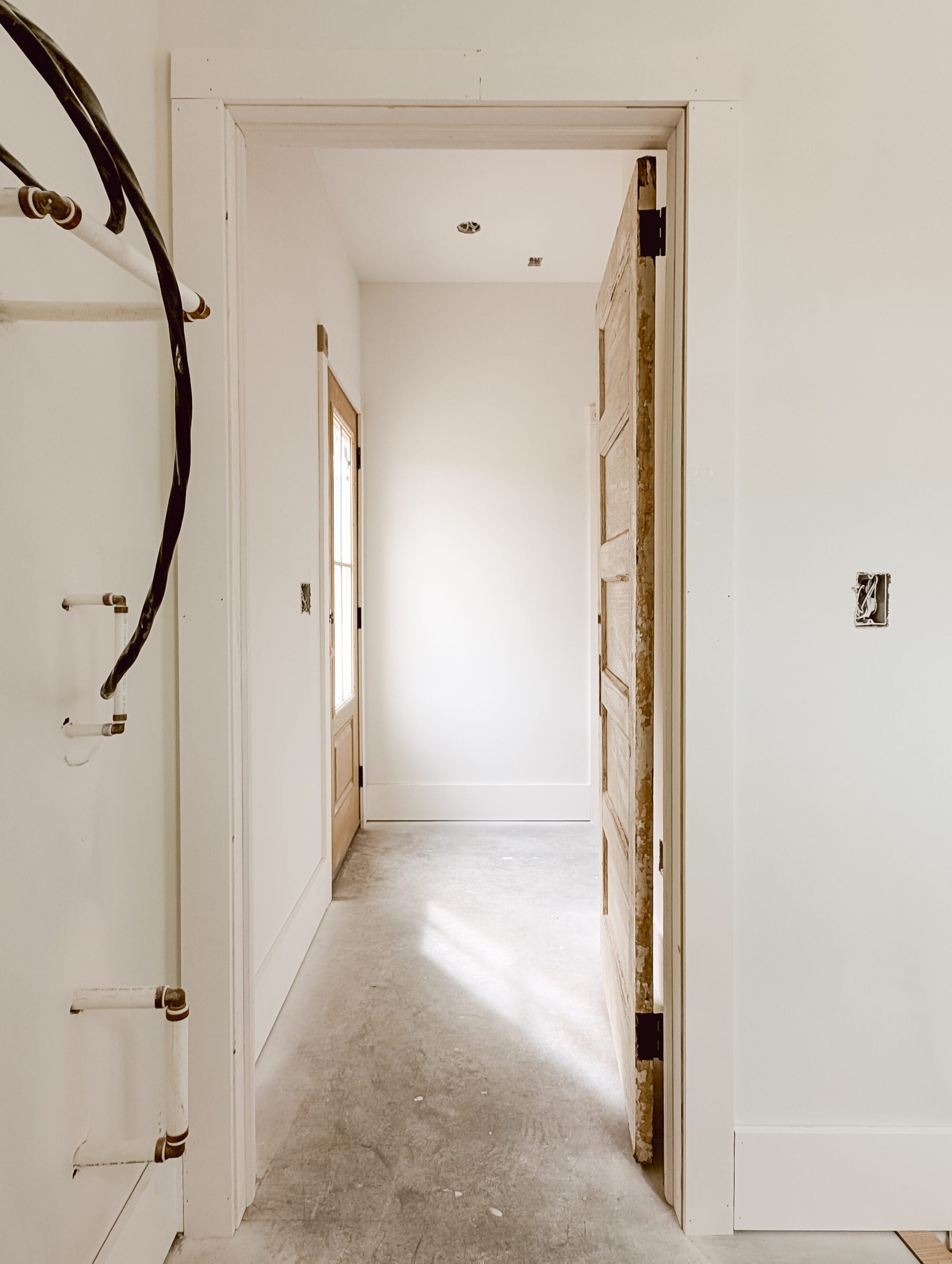 looking down the hallway from the laundry room to the back door