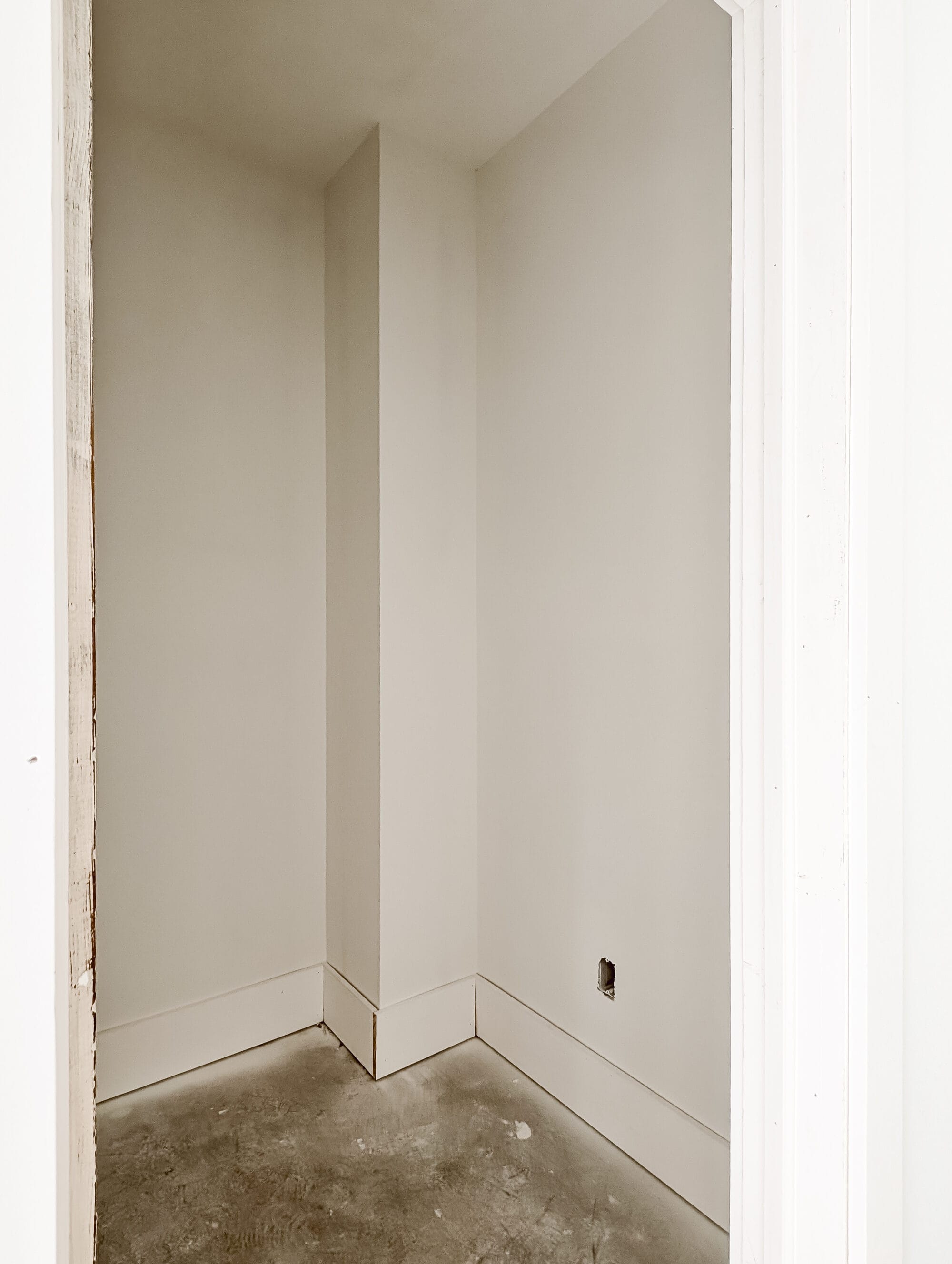 unfinished walk-in closet with primed walls and concrete subfloor