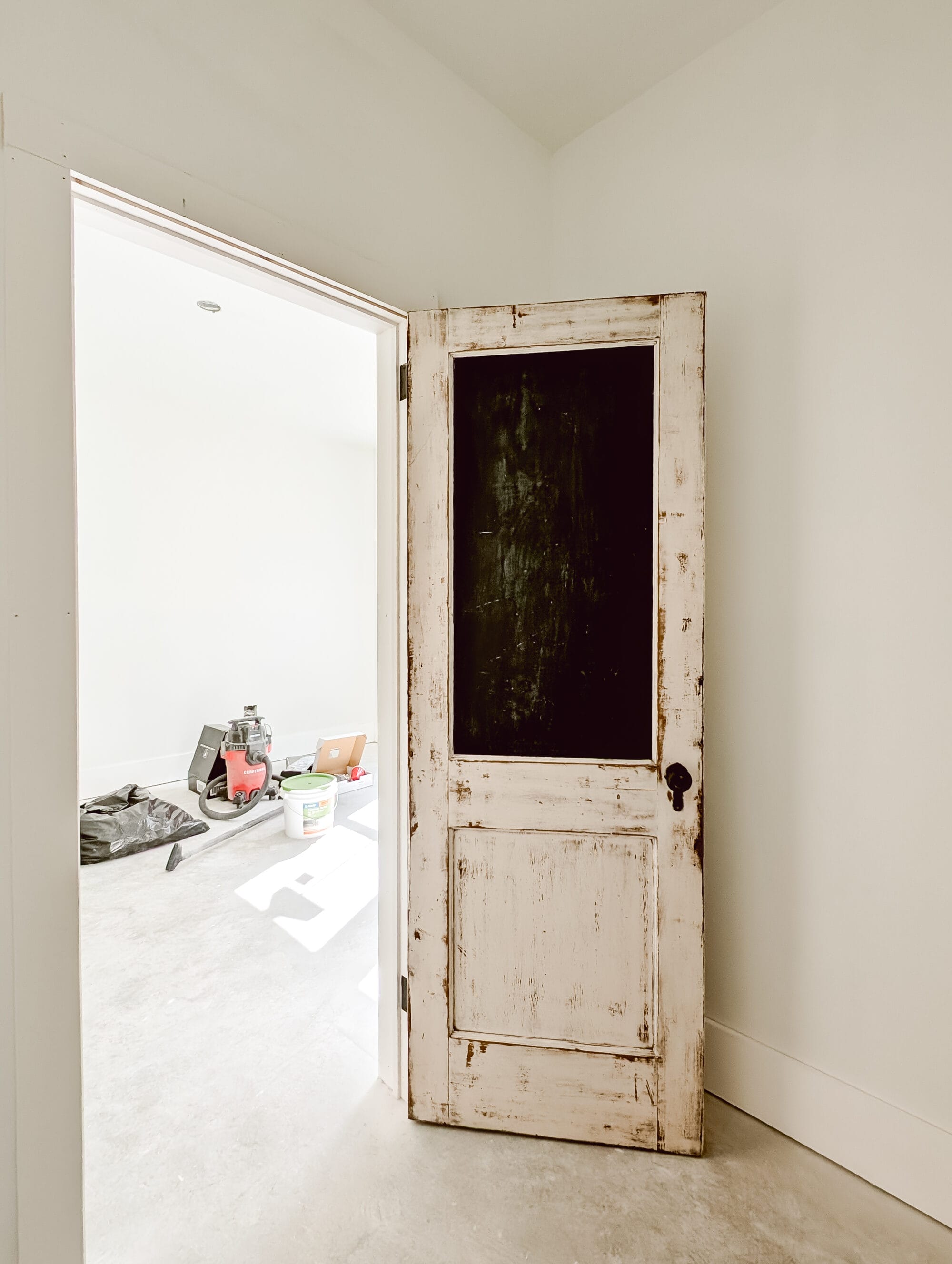 standing inside primary closet looking at antique closet door and our into the bedroom