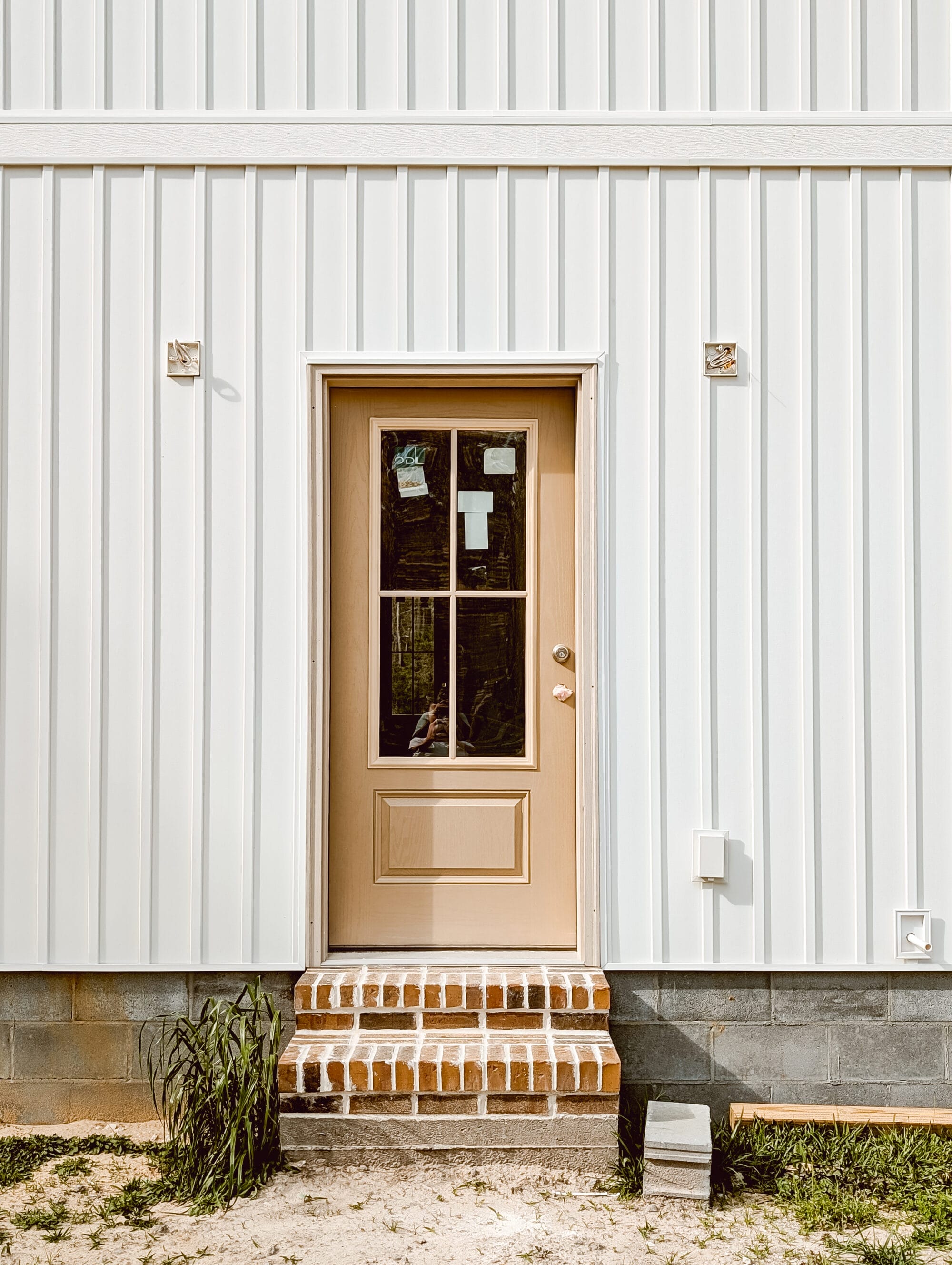 brick steps and an unpainted glass back door on the new old cottage we're building