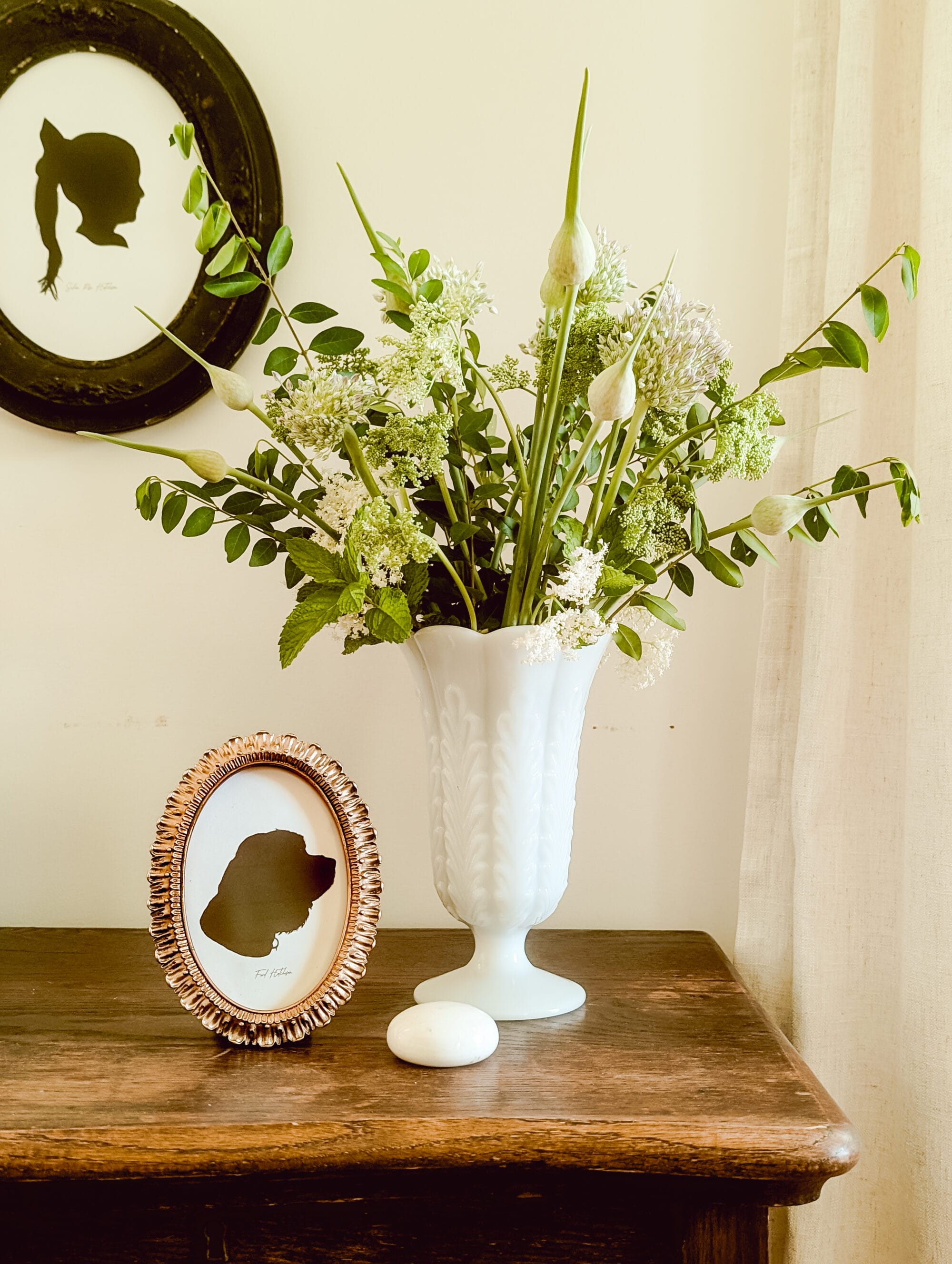 gold oval frame with black and white silhouette portrait of a cocker spaniel dog