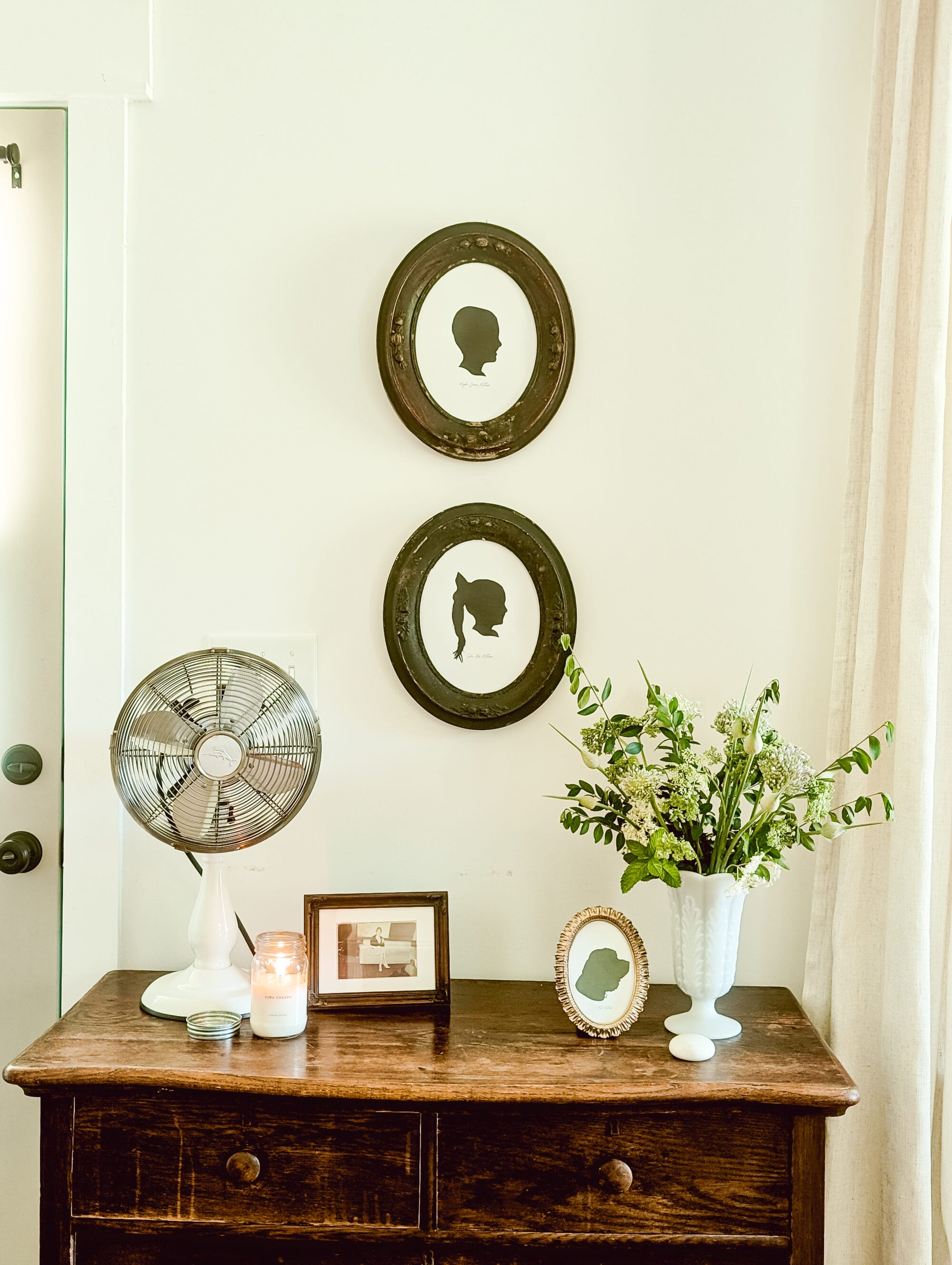 DIY silhouette portraits of children in antique oval frames hung on the wall 