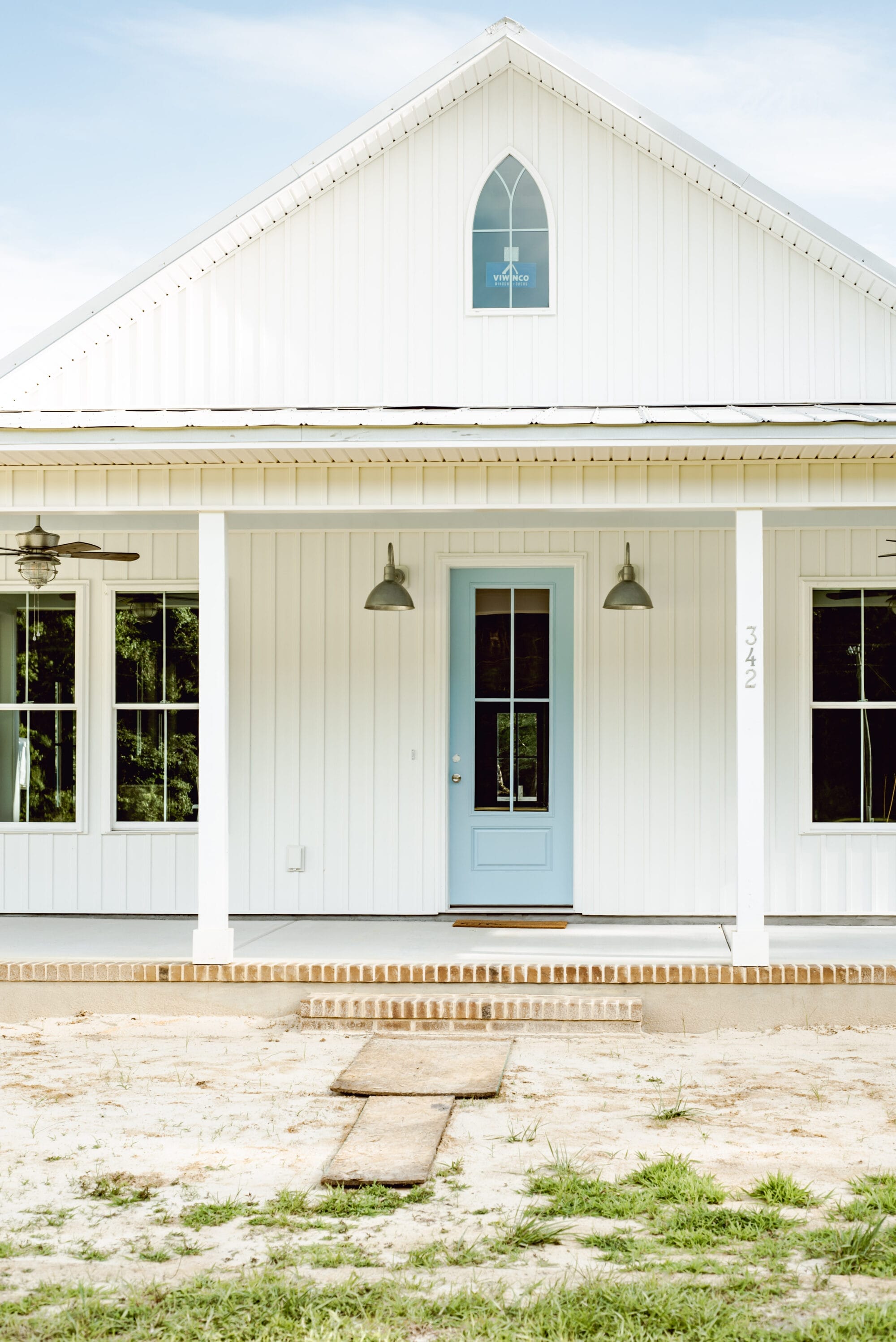 pointed arch window on a white country cottage inspired by American Carpenter Gothic style architecture
