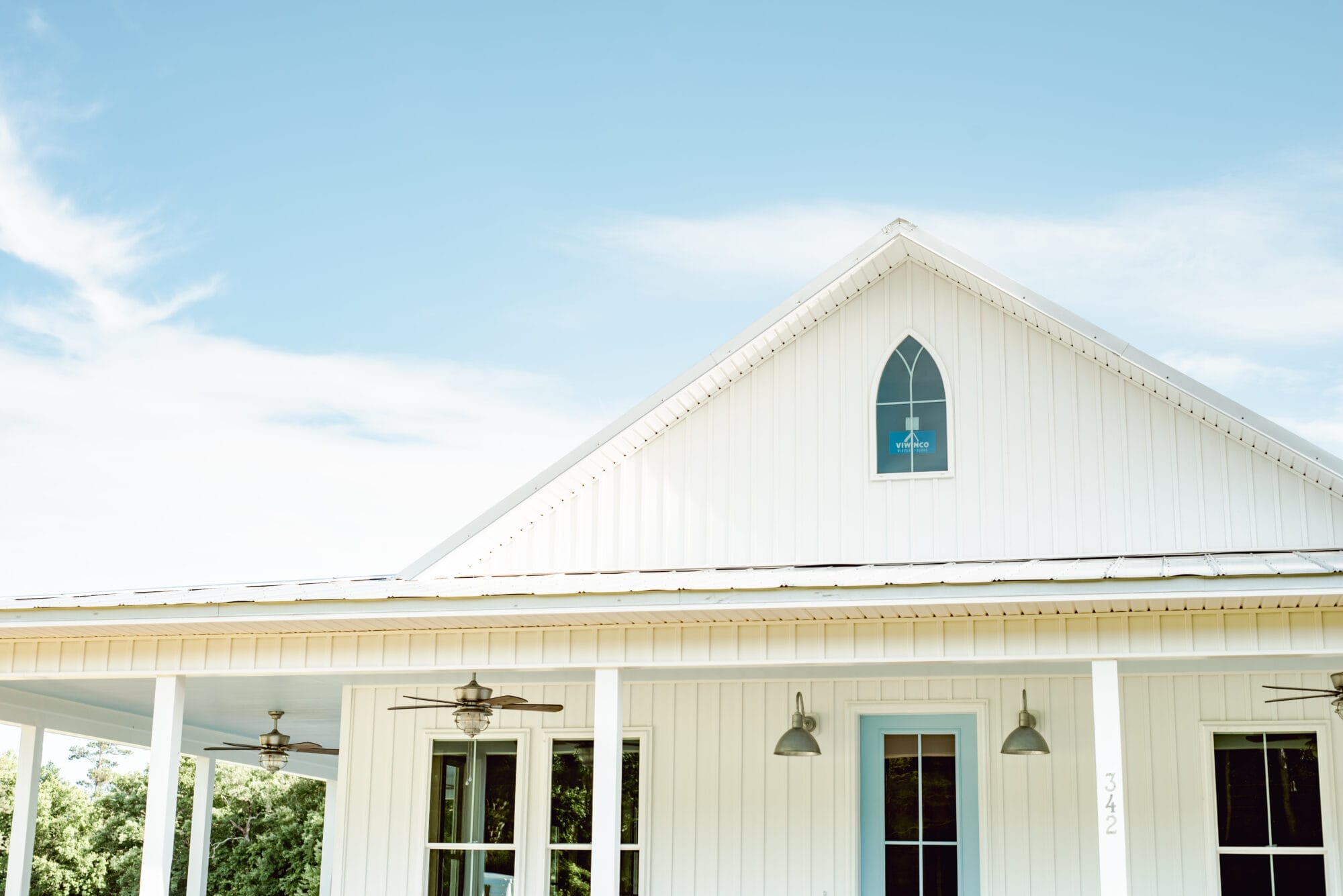 arched window on a white country cottage inspired by American Carpenter Gothic style architecture