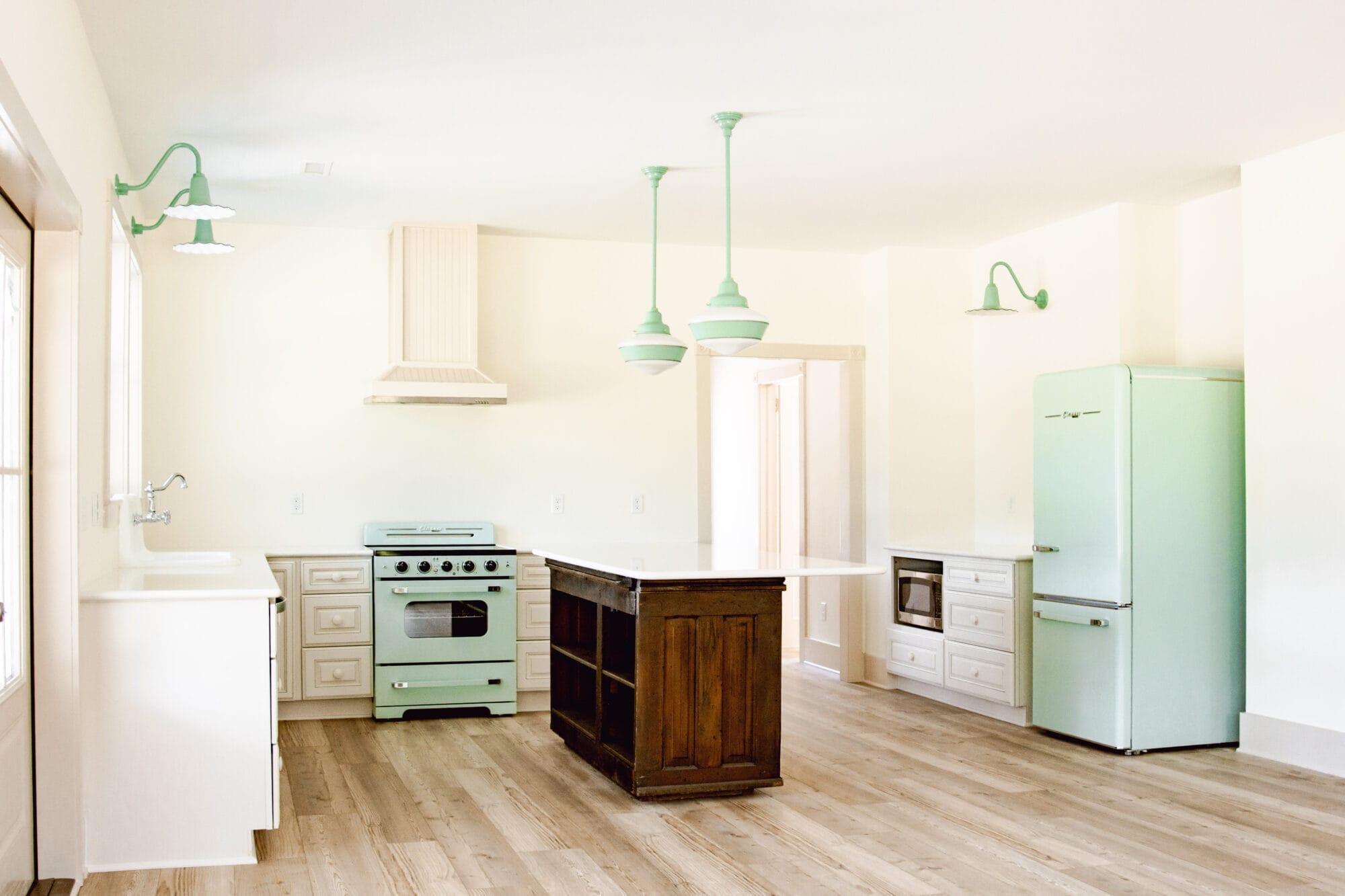 new old cottage kitchen with pops of mint green and an antique wood island