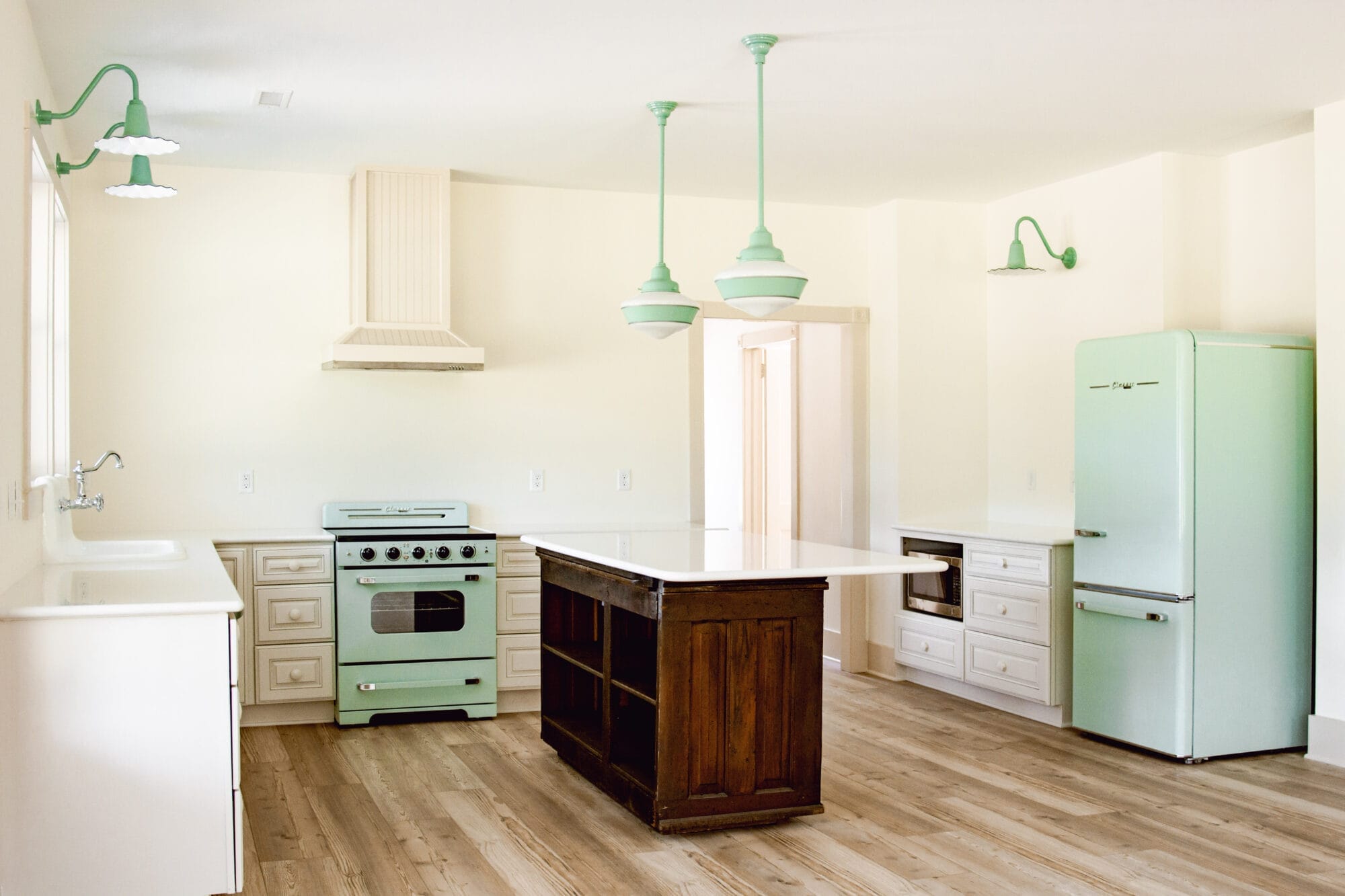 vintage cottage style kitchen with pops of minty green and an antique general store counter as the island