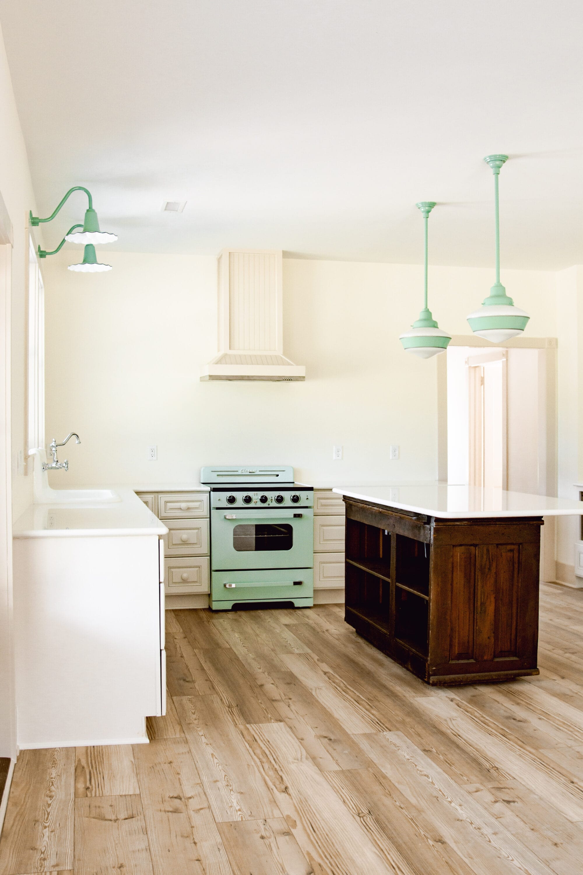 white cottage kitchen with retro mint green stove and vintage inspired jadeite green lights