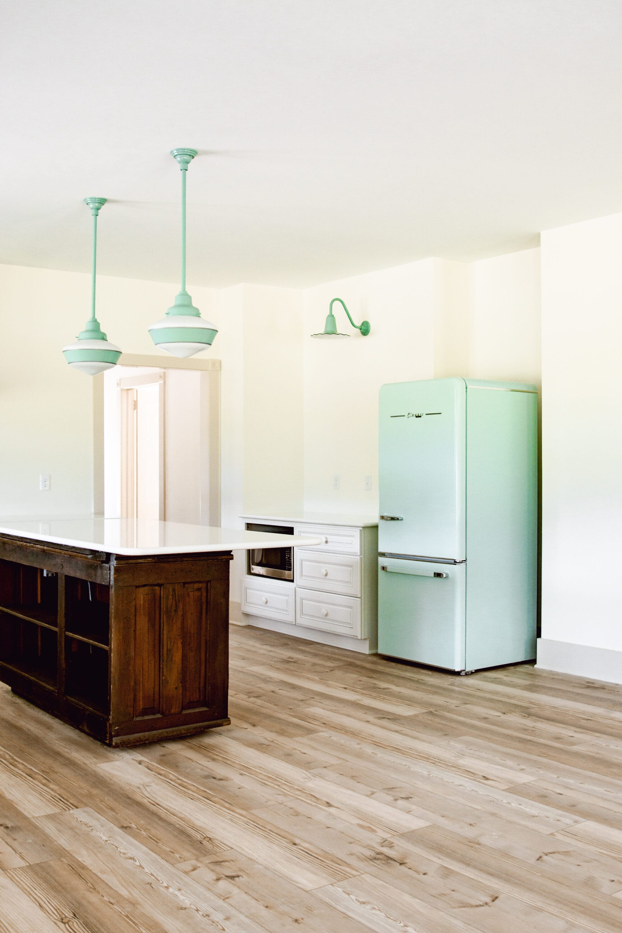 white cottage kitchen with retro mint green fridge and vintage inspired jadeite green lights