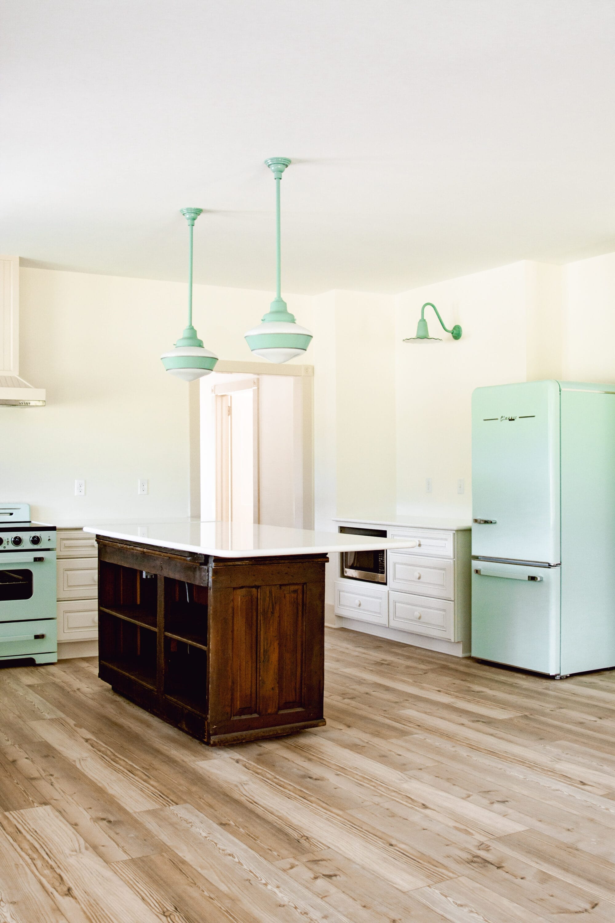 white cottage kitchen with retro mint green appliance and vintage inspired jadeite green lights