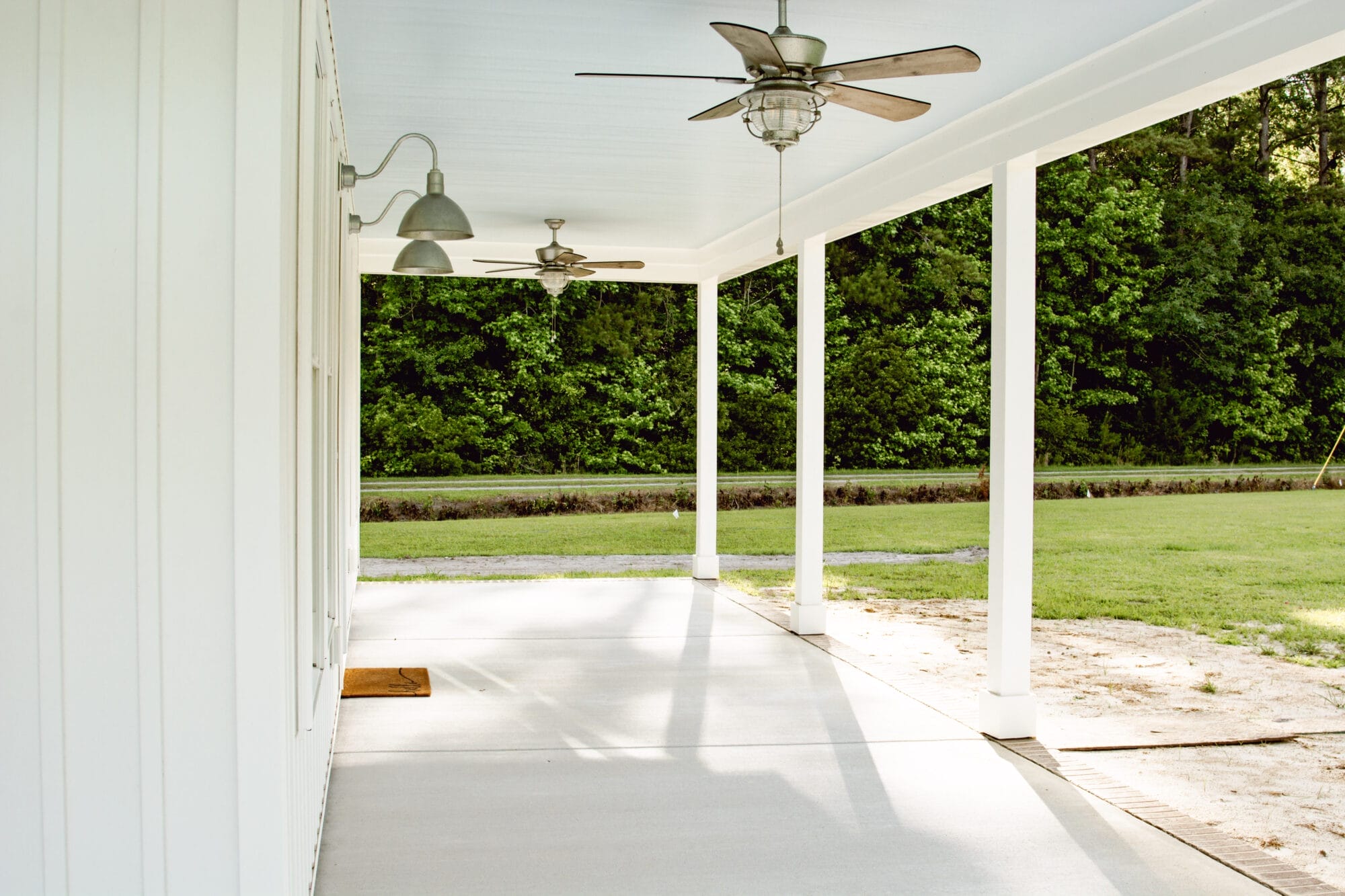 haint blue porch ceilings on a white cottage house with galvanized exterior lighting