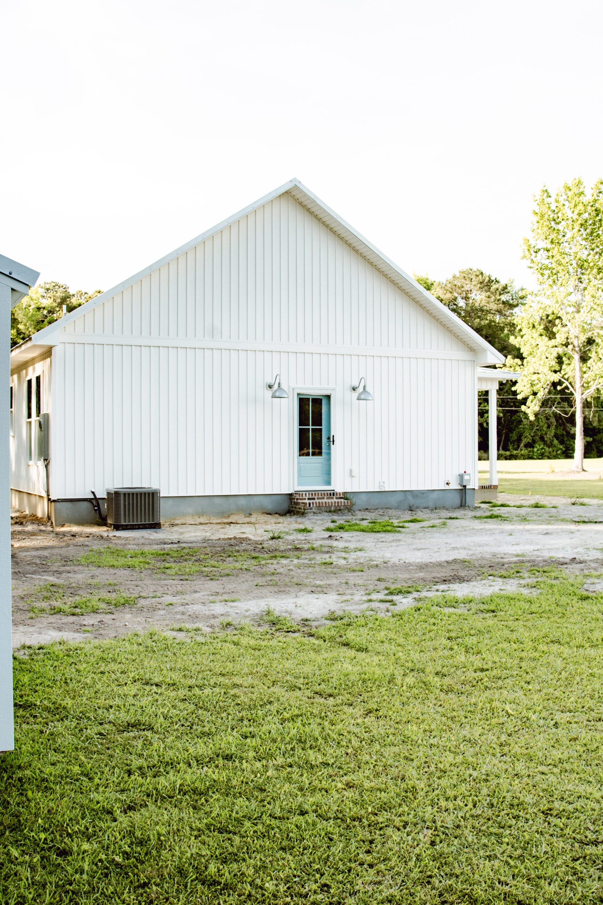 galvanized wilcox deep bowl gooseneck lights from Barn Light Electric on a white cottage with board and batten siding