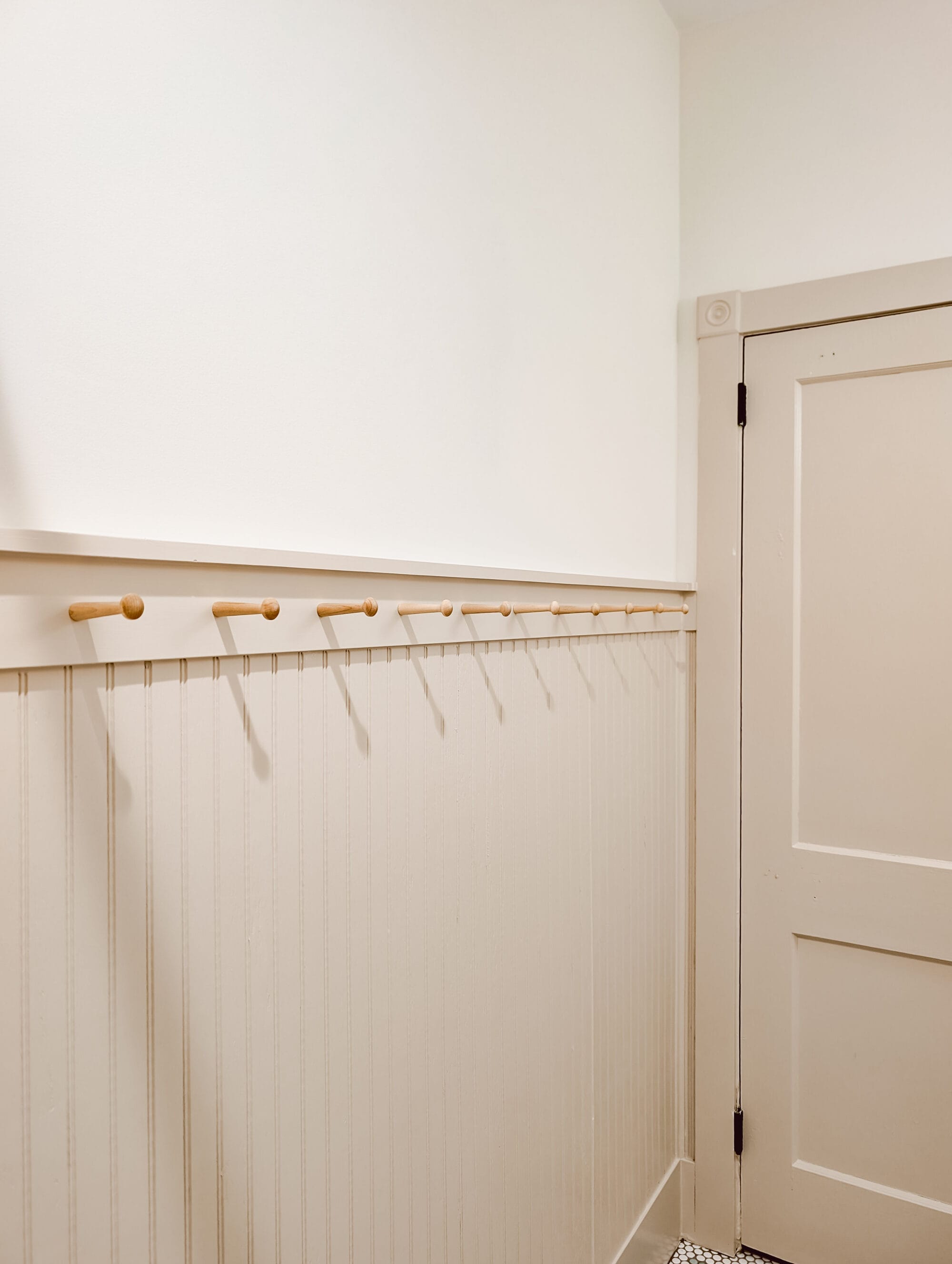 bathroom beadboard paneling with a peg rail shelf on top