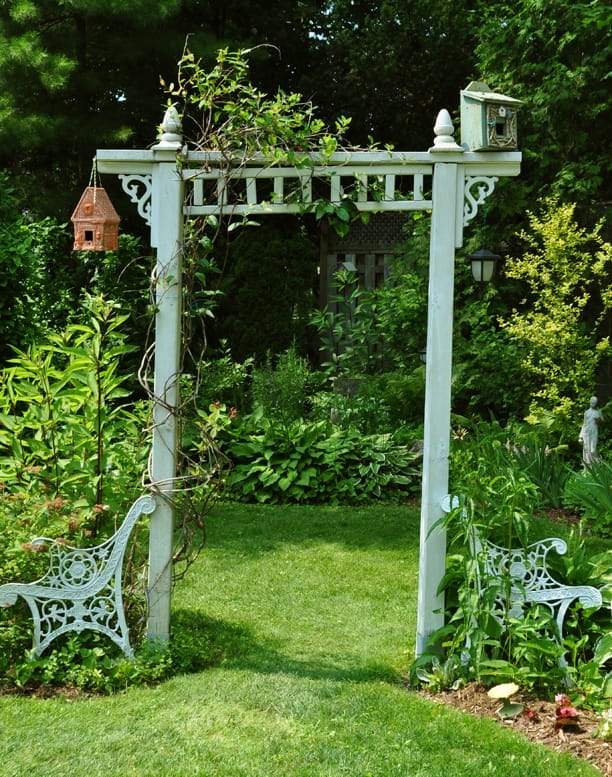 green country garden arbor with 2 wood finials on top, two corbels on either side, and a salvaged trim piece in the middle