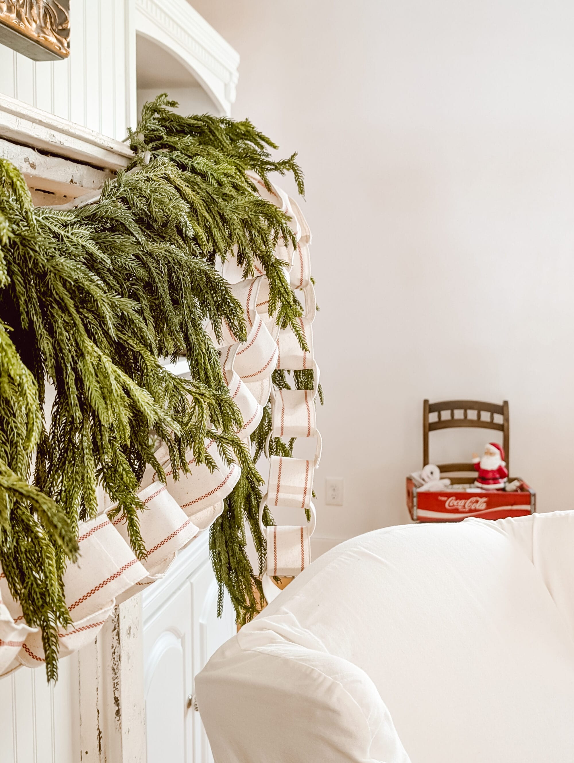 norfolk pine greenery and a ribbon chain garlands layered on the mantle