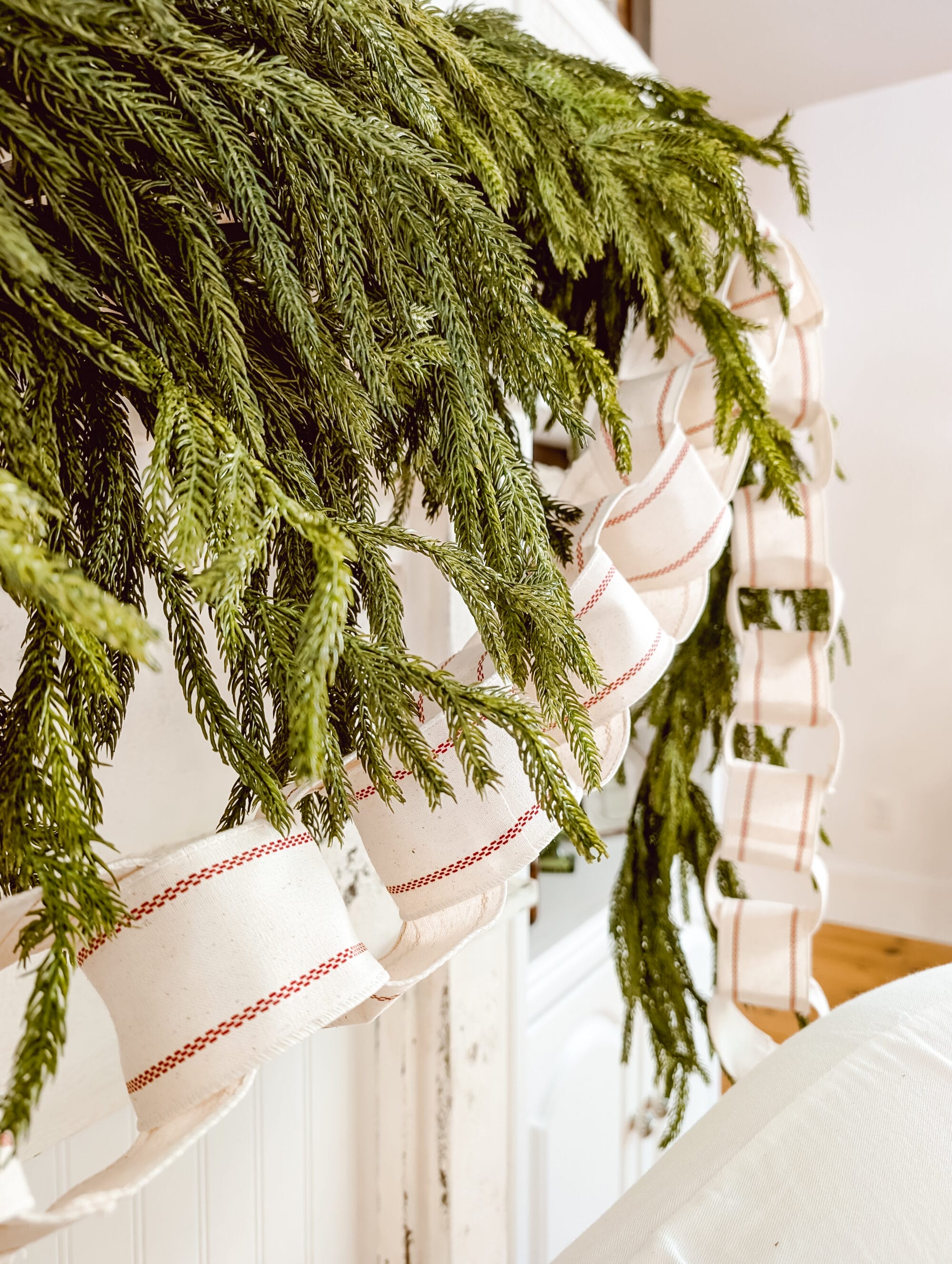 wired ribbon turned into a DIY ribbon chain Christmas garland and hung on an antique mantel