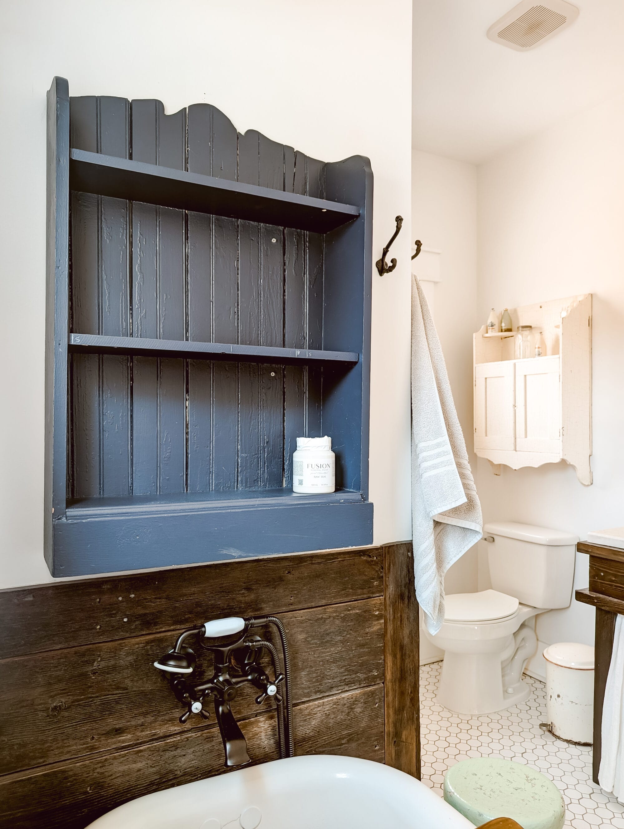 small blue bookshelf hung on the bathroom wall