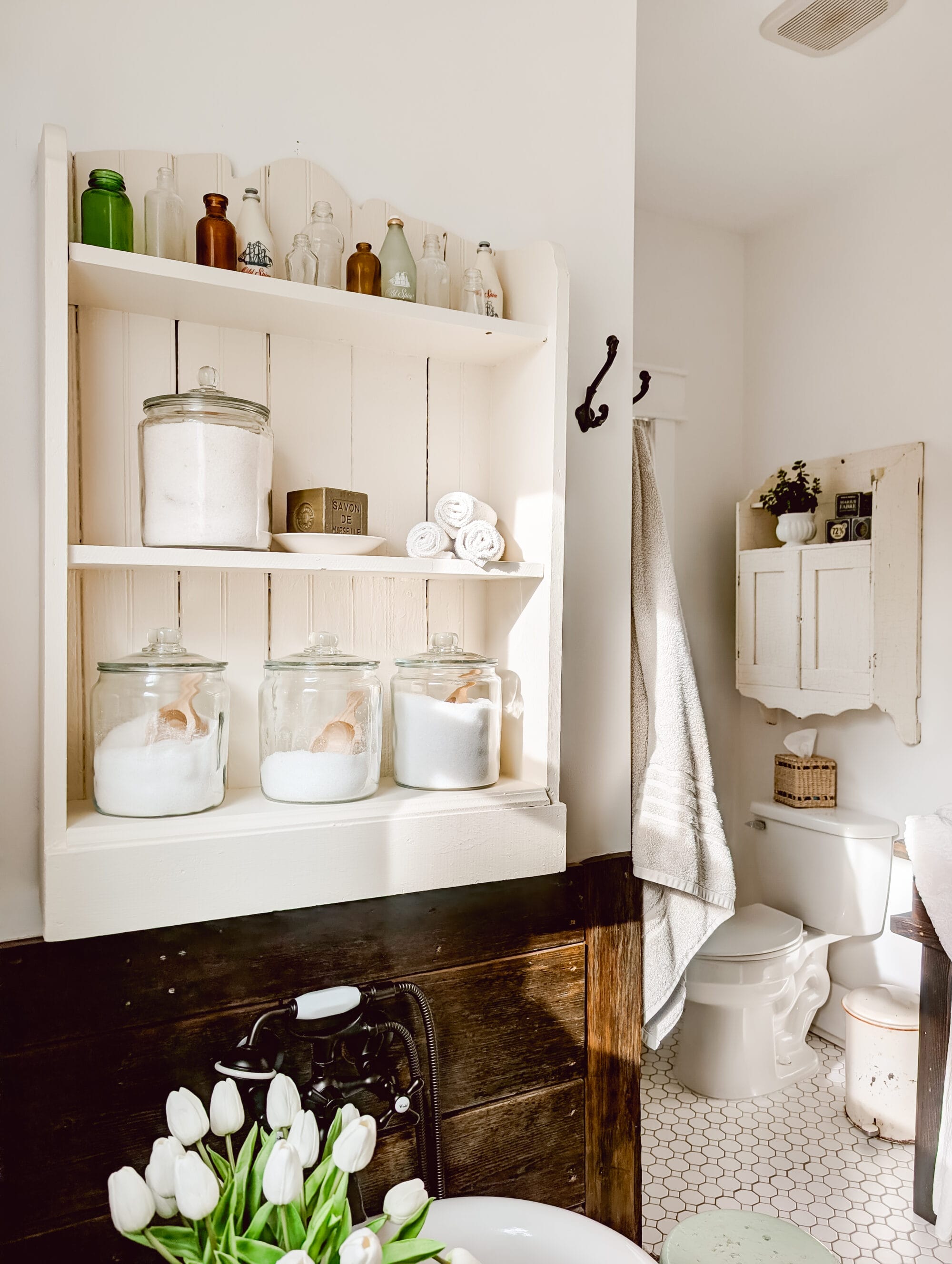 vintage bookshelf and vintage medicine cabinet hung on the bathroom walls